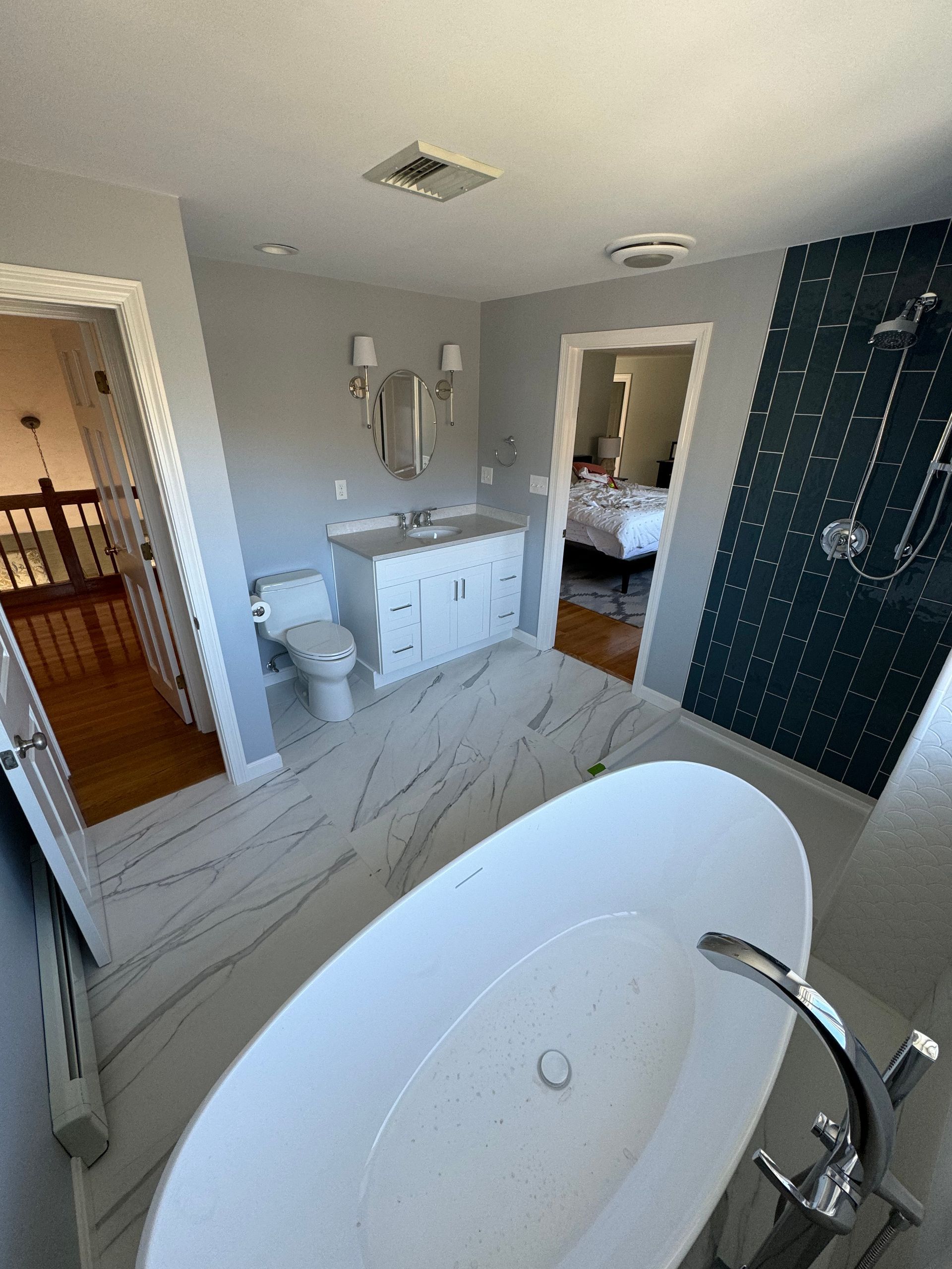 A bathroom with a bathtub , toilet , sink and shower.