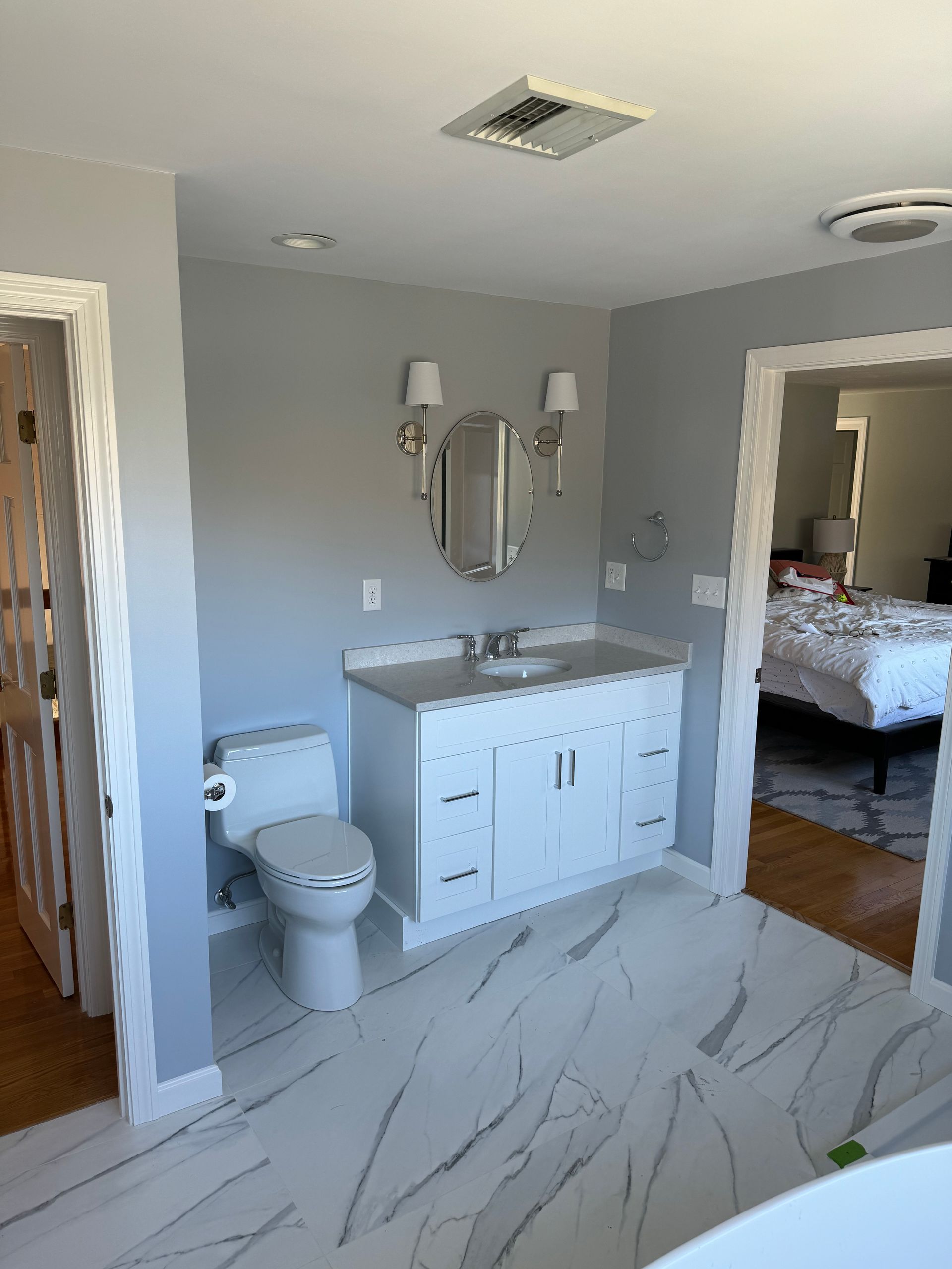 A bathroom with a toilet , sink and mirror.