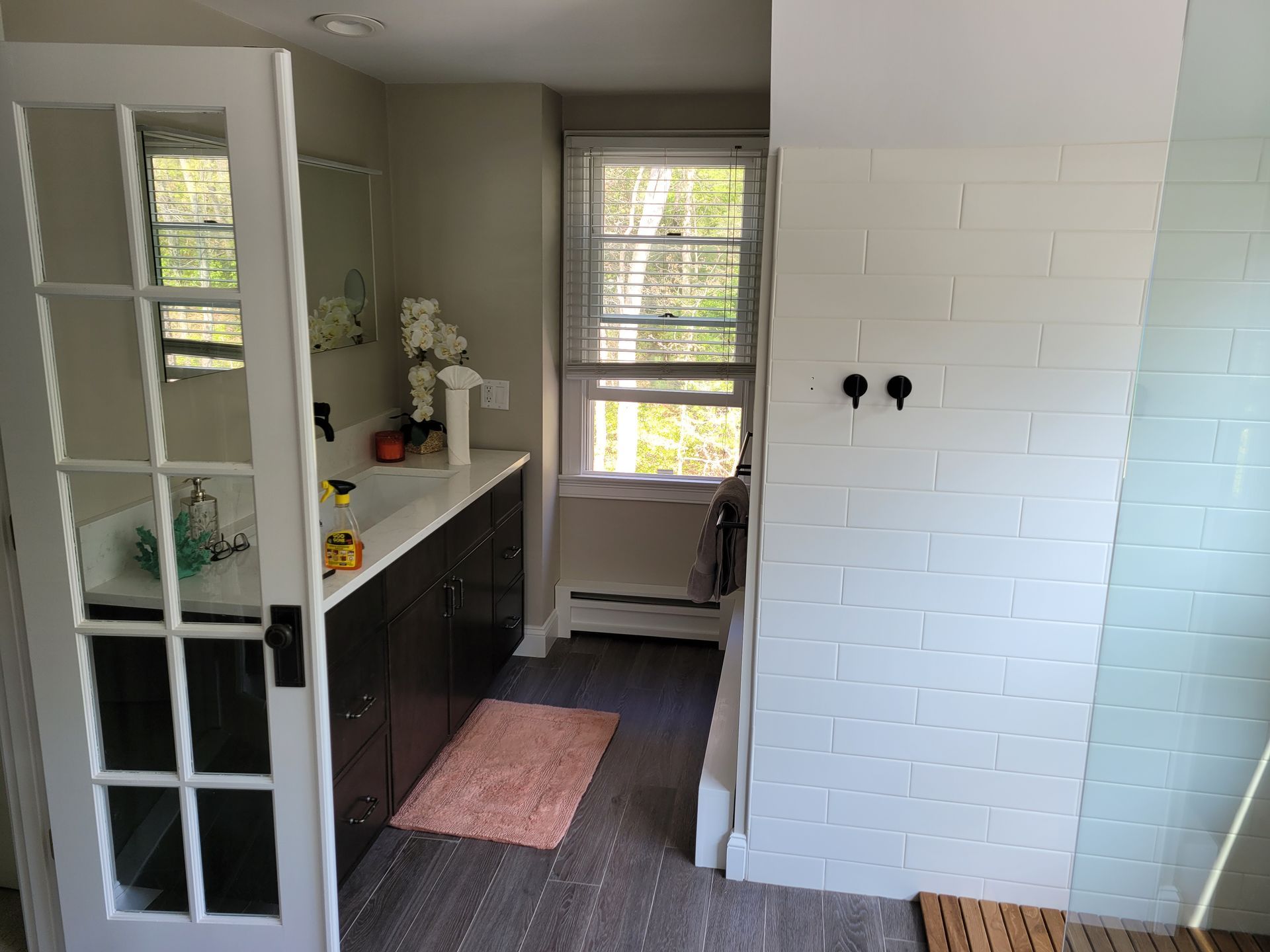 A bathroom with a sink and a window with french doors