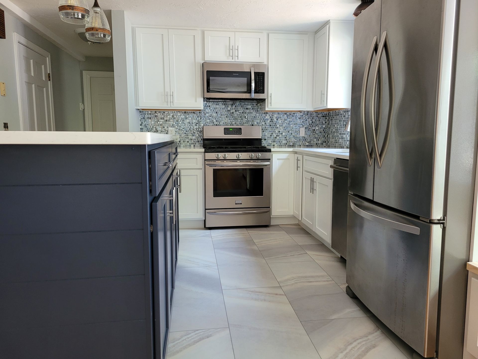 A kitchen with stainless steel appliances and white cabinets