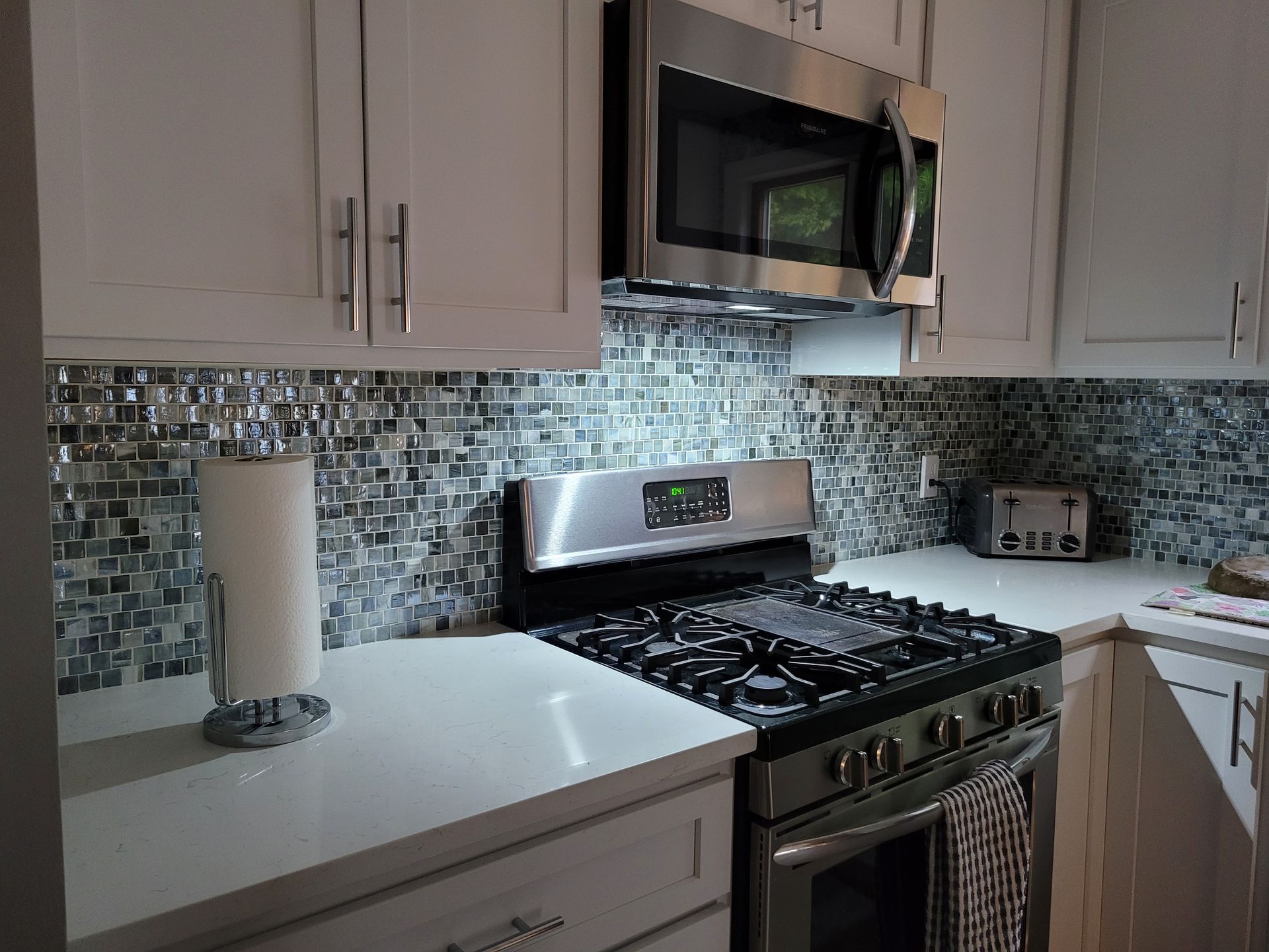 A kitchen with stainless steel appliances and white cabinets