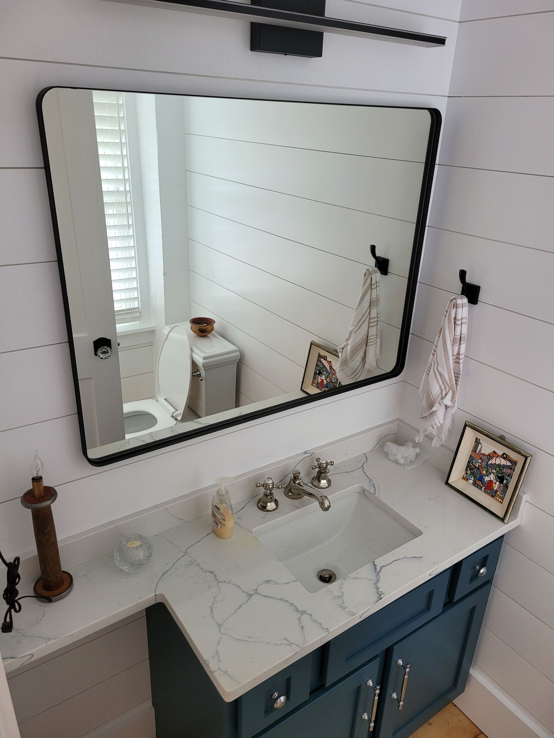 A bathroom with a sink , mirror and toilet.