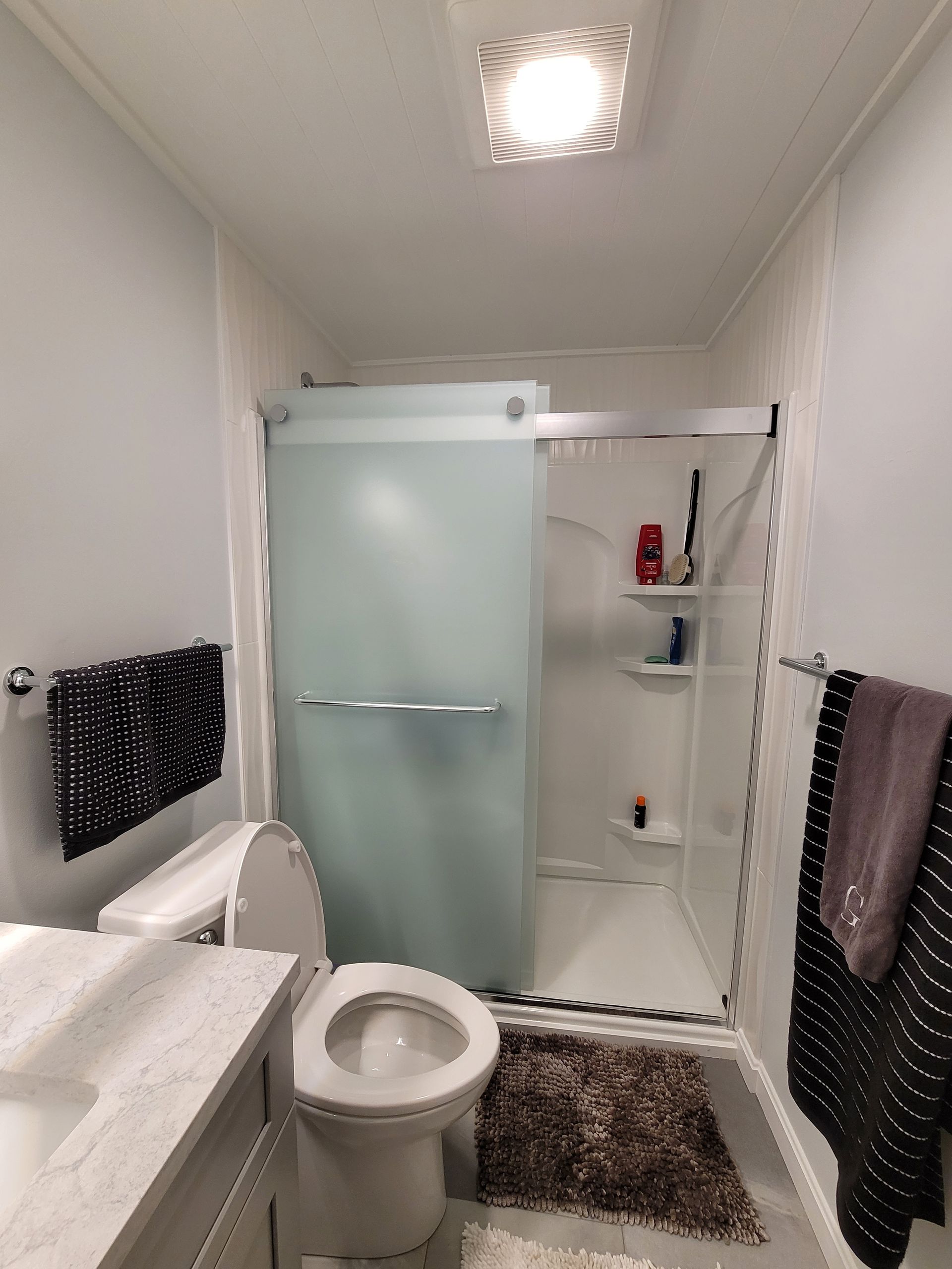 A bathroom with a toilet , sink , and shower.