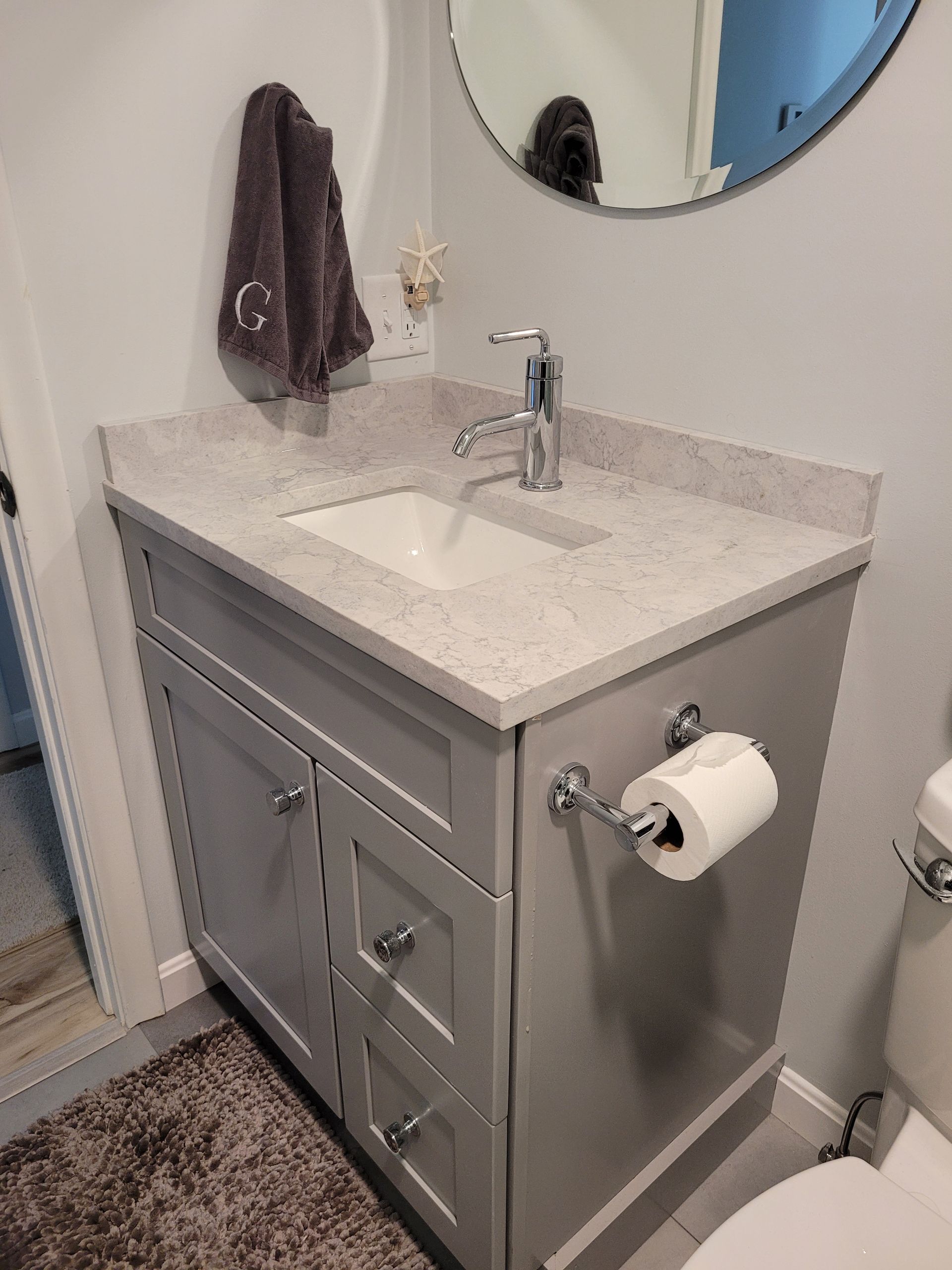 A bathroom with a sink , toilet and mirror.