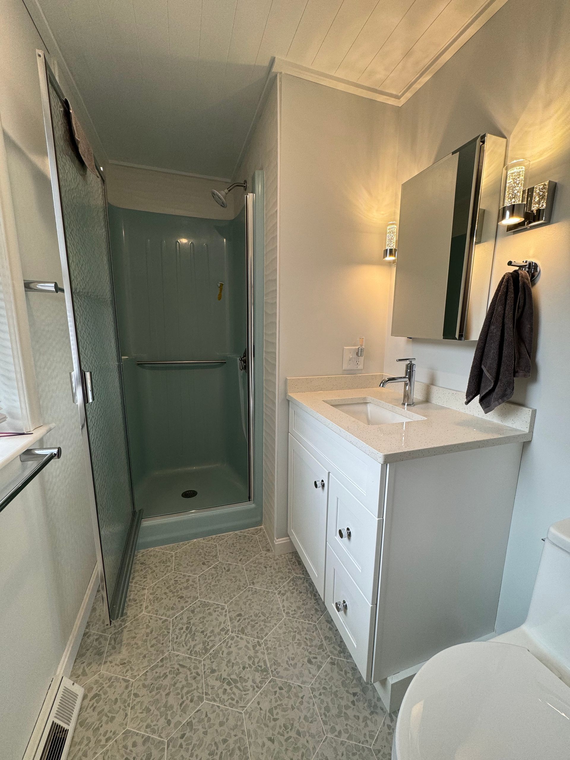 A bathroom with a sink , toilet and shower.