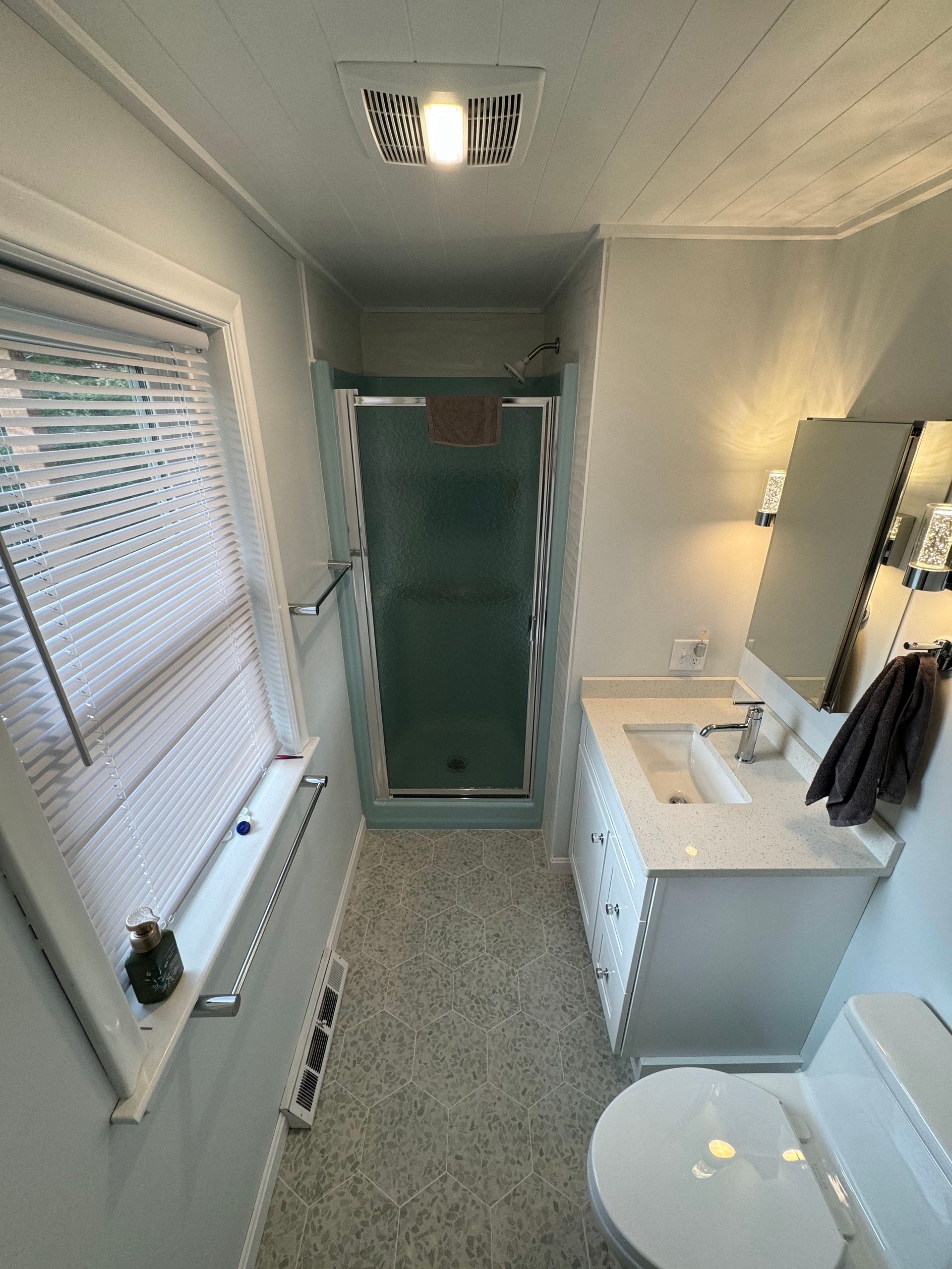A bathroom with a toilet , sink , and shower.