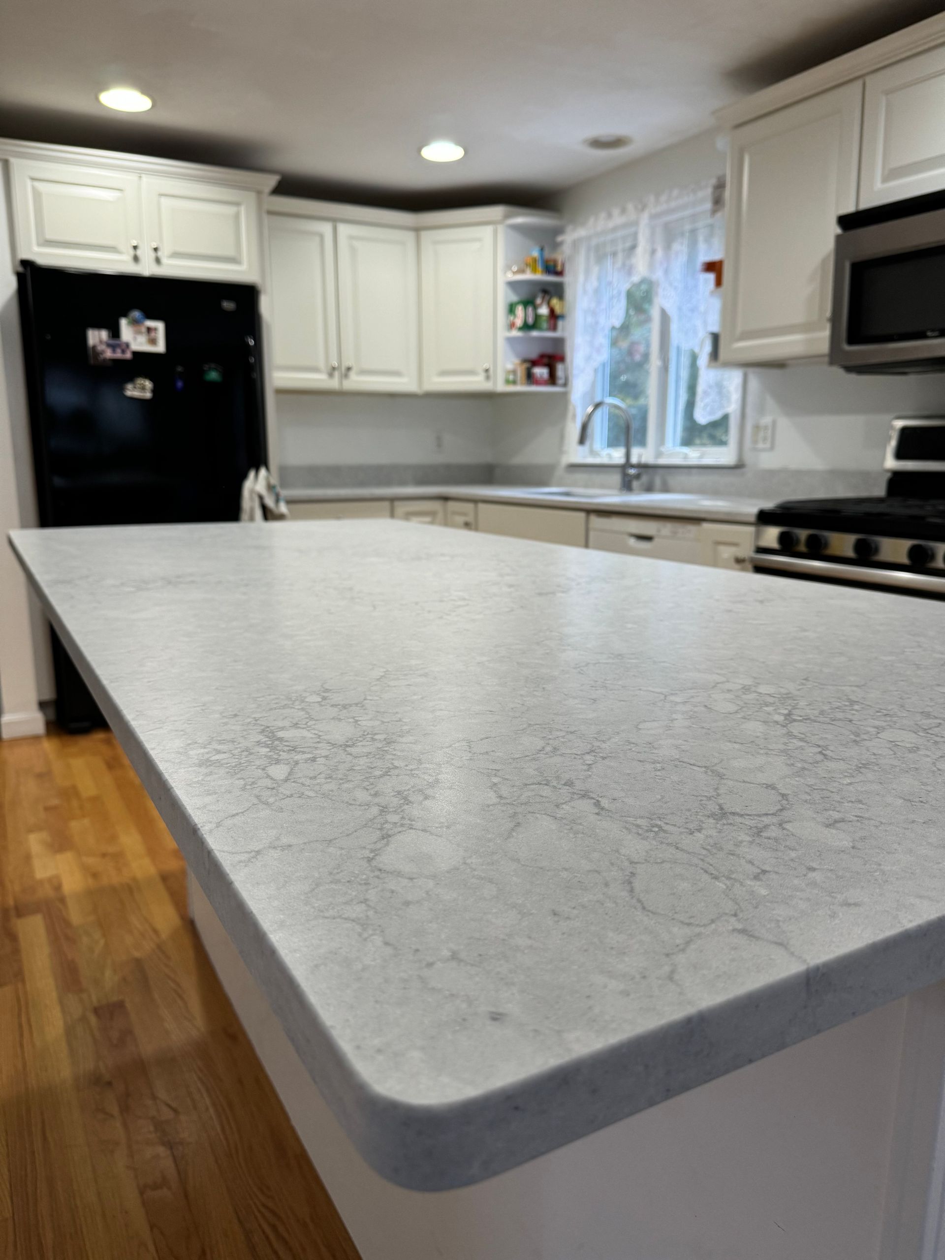 A kitchen with white cabinets and a large white counter top.