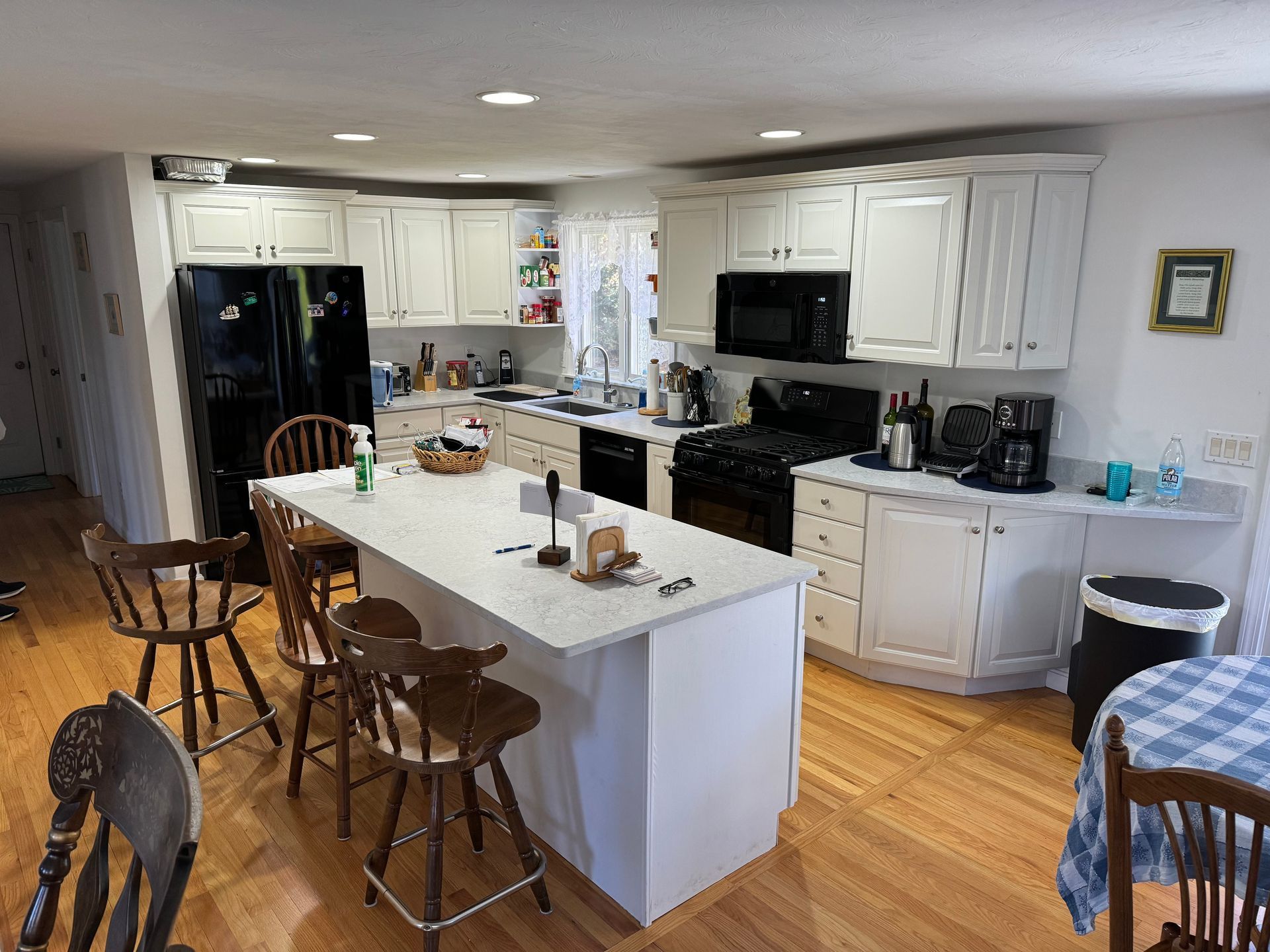 A kitchen with white cabinets and a large island in the middle.