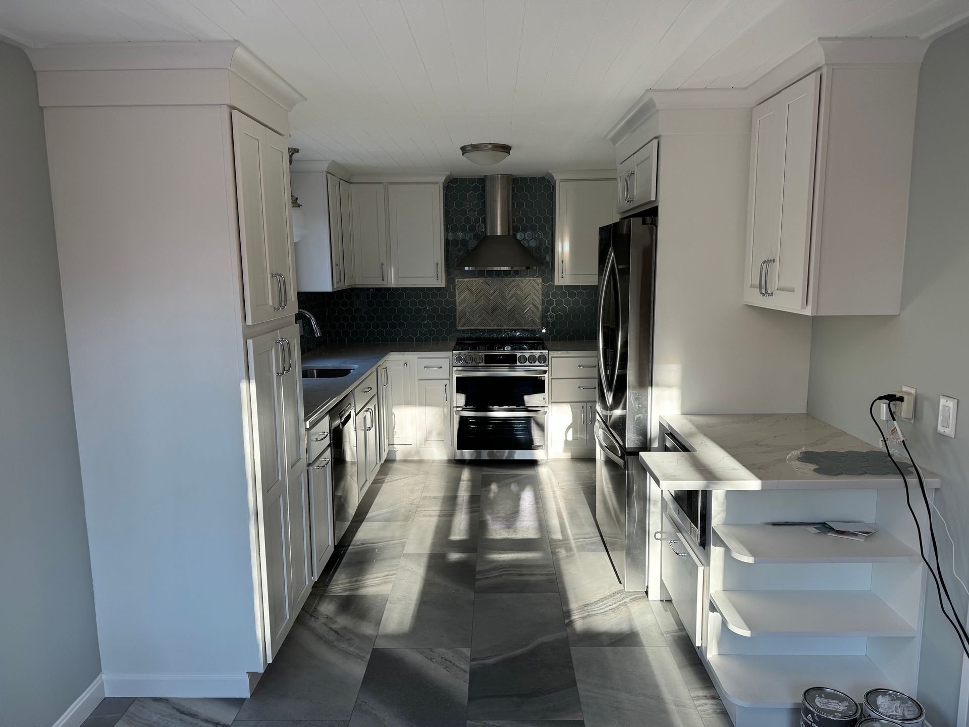 A kitchen with white cabinets and stainless steel appliances