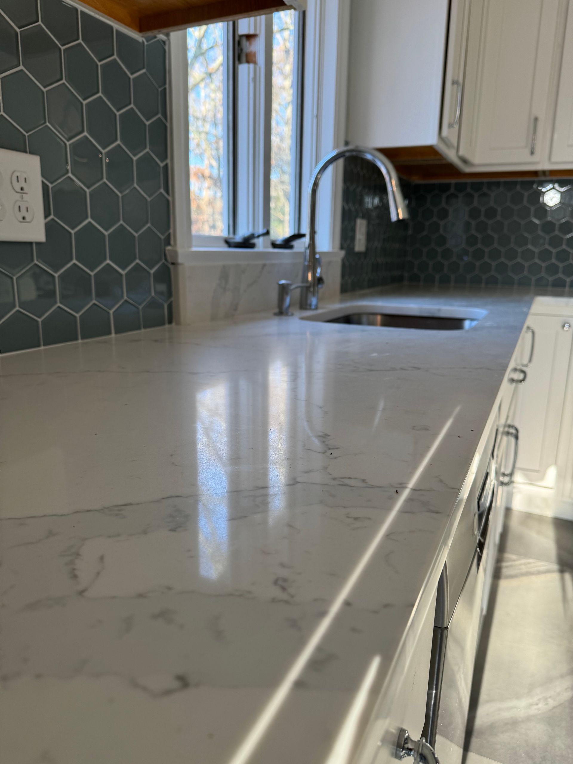 A kitchen counter with a sink and a window