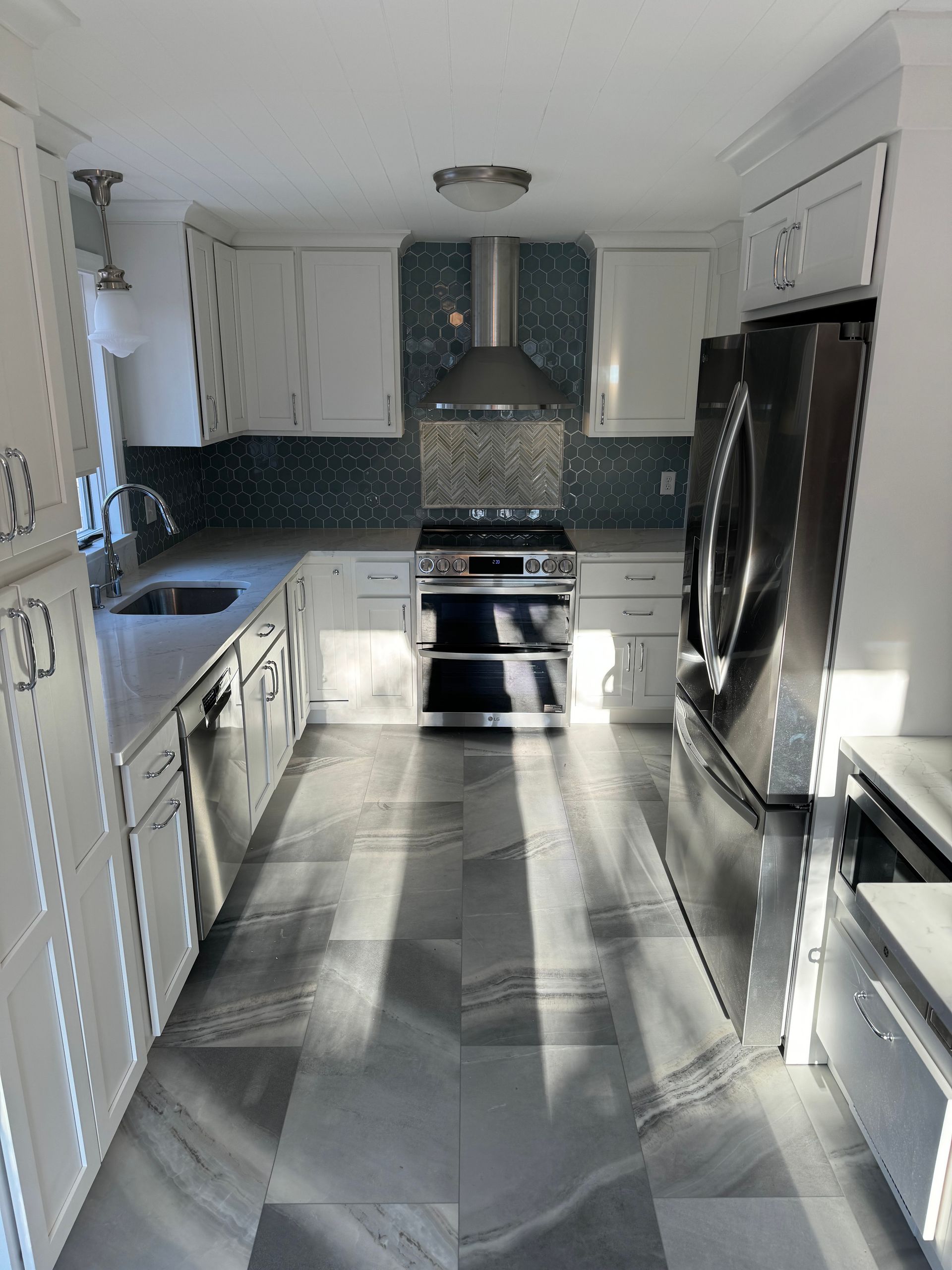 A kitchen with stainless steel appliances and white cabinets
