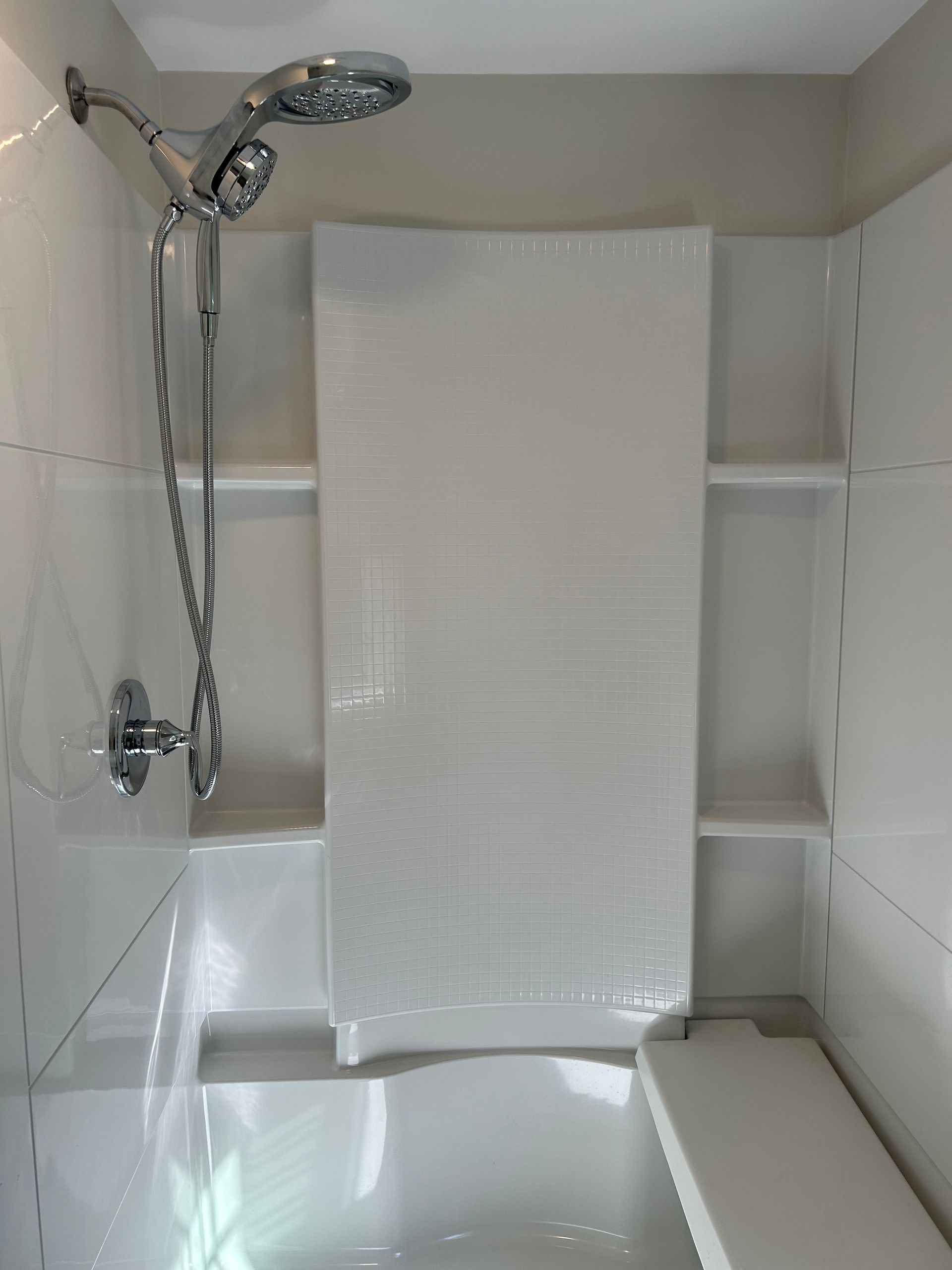 A bathroom with a shower head and a bathtub