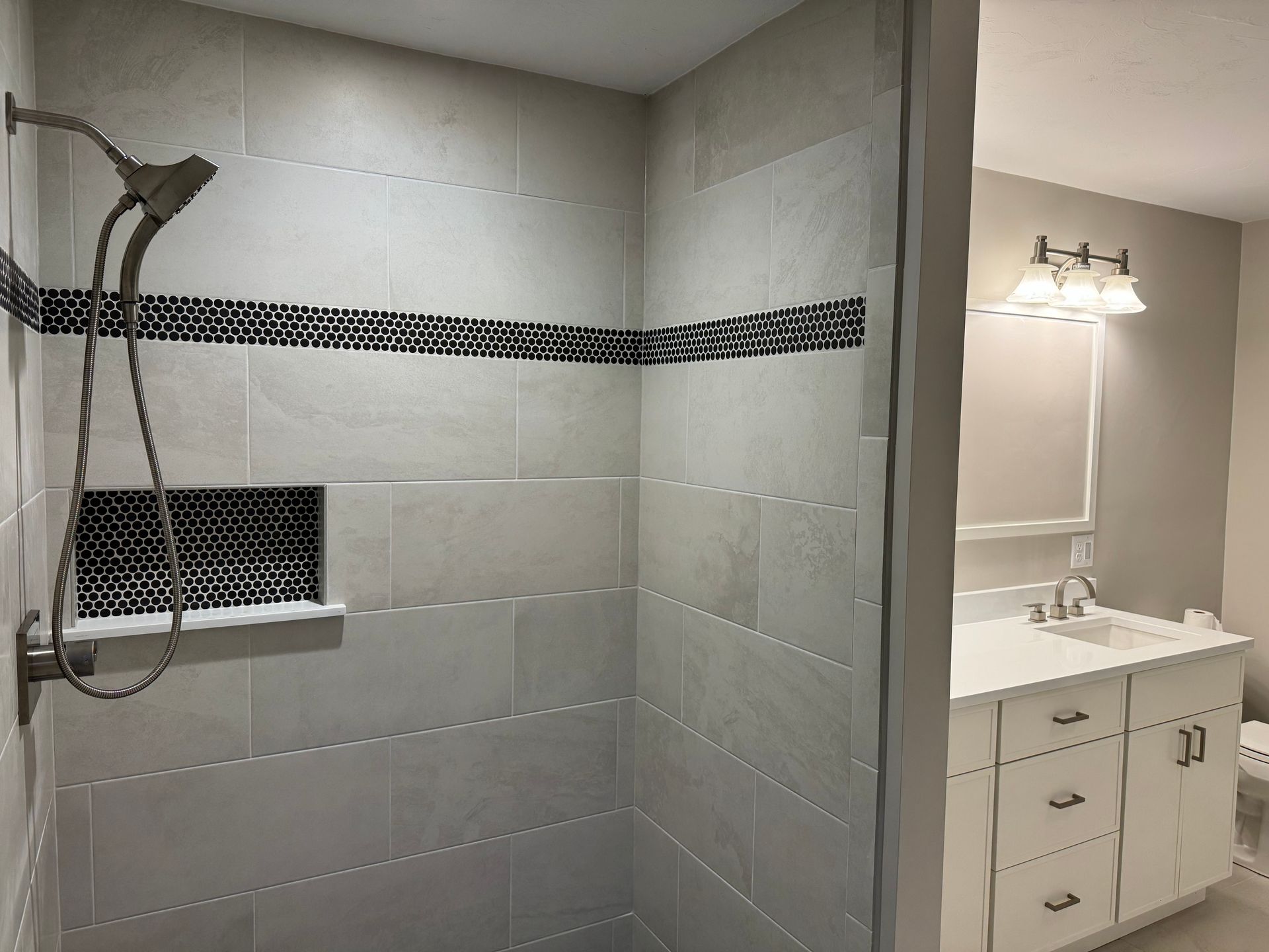 A bathroom with a walk in shower and a sink.