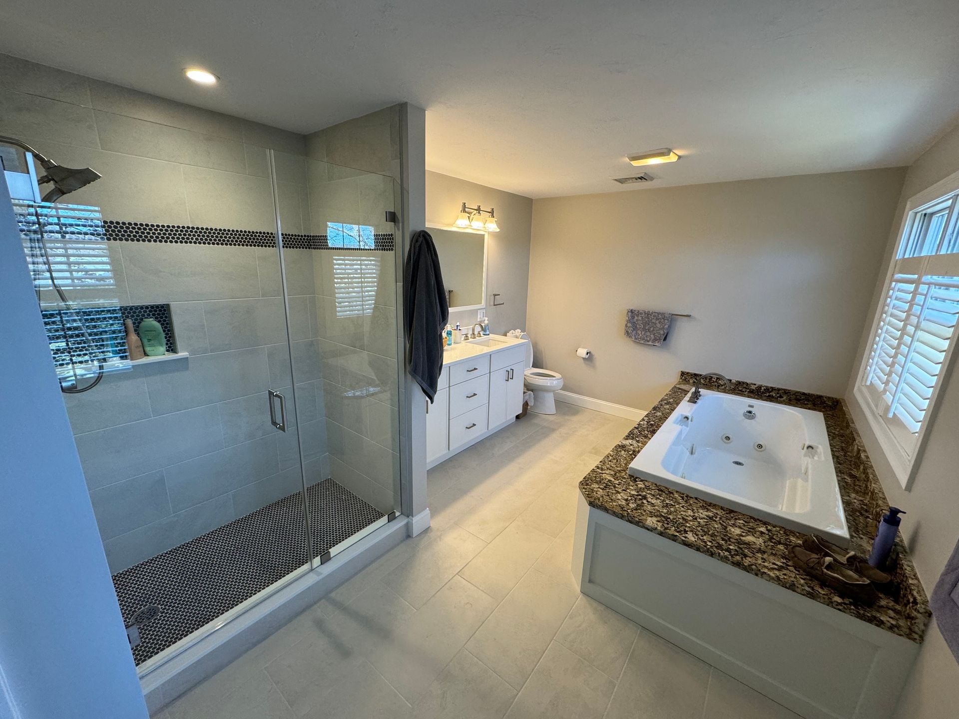 A bathroom with a tub , shower , sink and toilet.