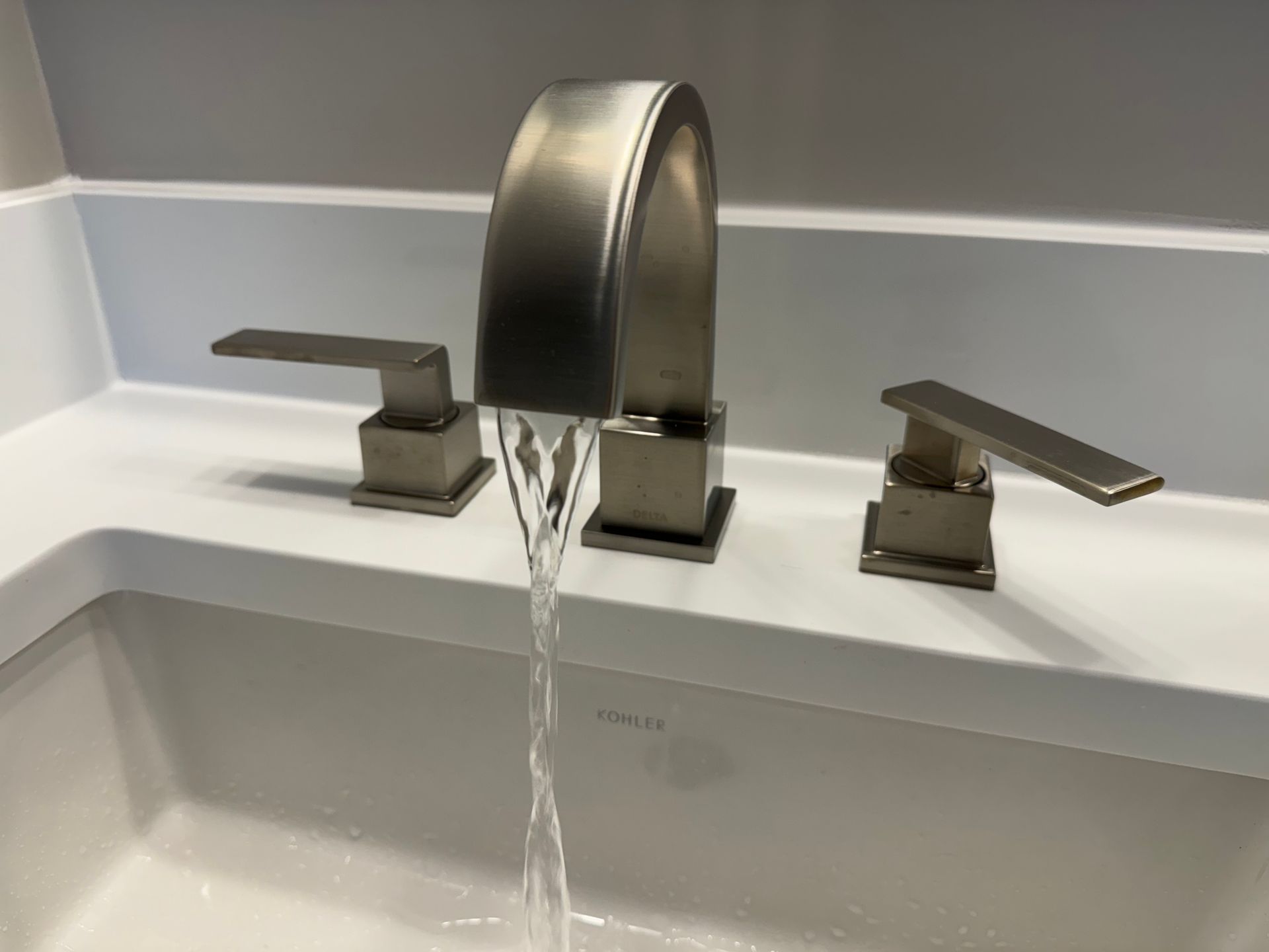 A close up of a sink faucet with water running out of it