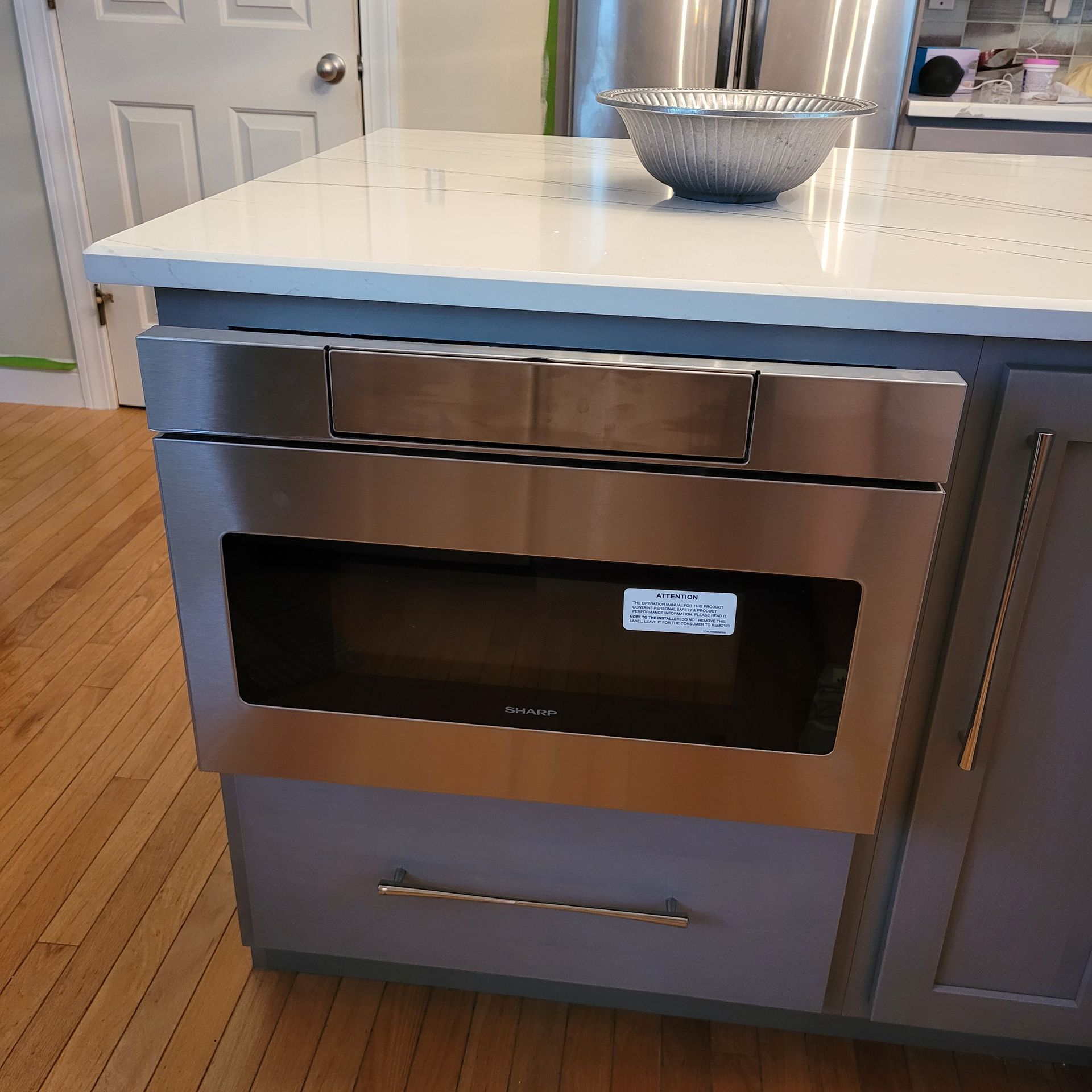 A stainless steel oven is sitting on top of a kitchen island