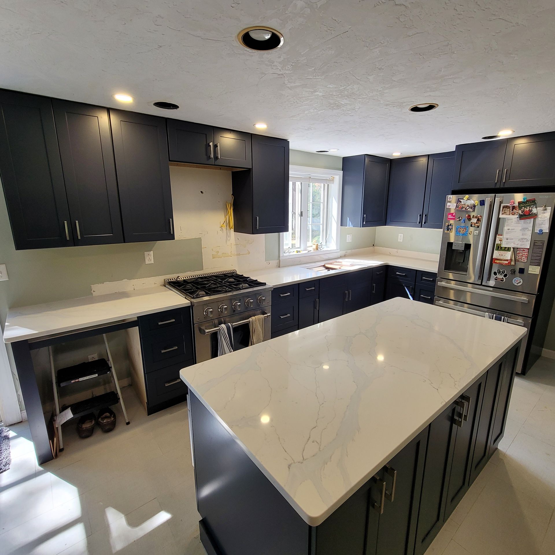 A kitchen with black cabinets and white counter tops