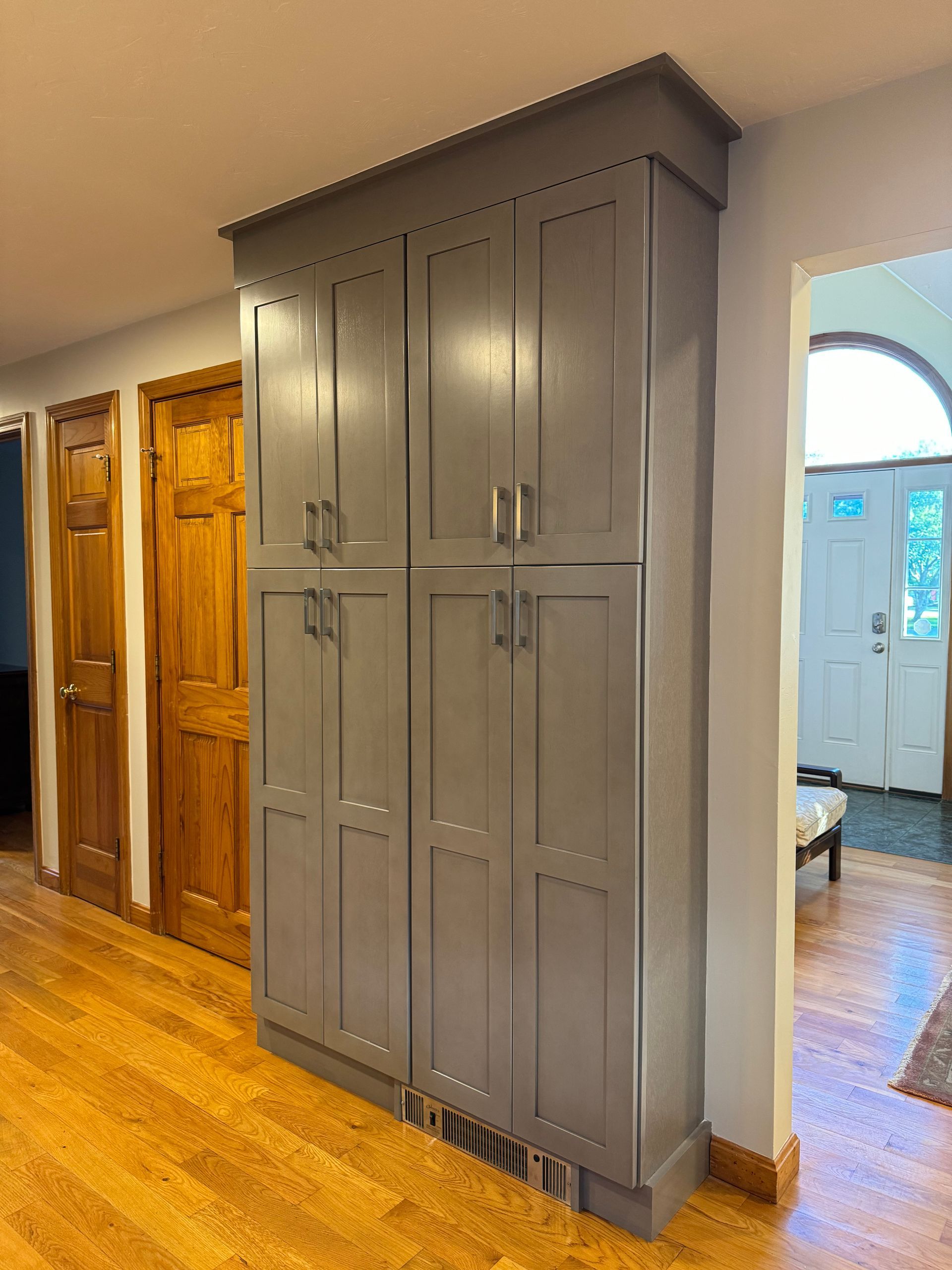 A large gray cabinet in a kitchen with wooden floors