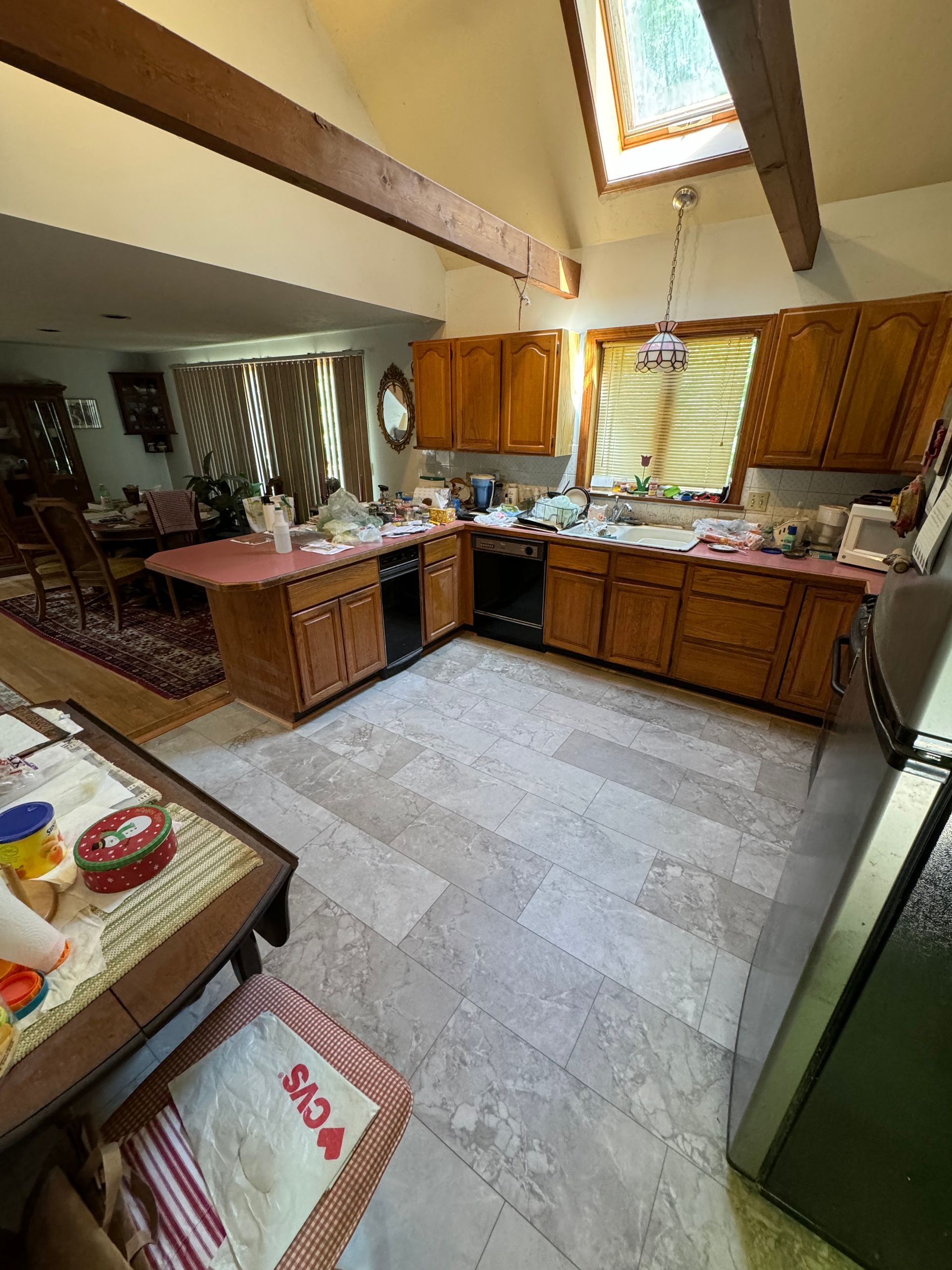 A kitchen with wooden cabinets and a stainless steel refrigerator.