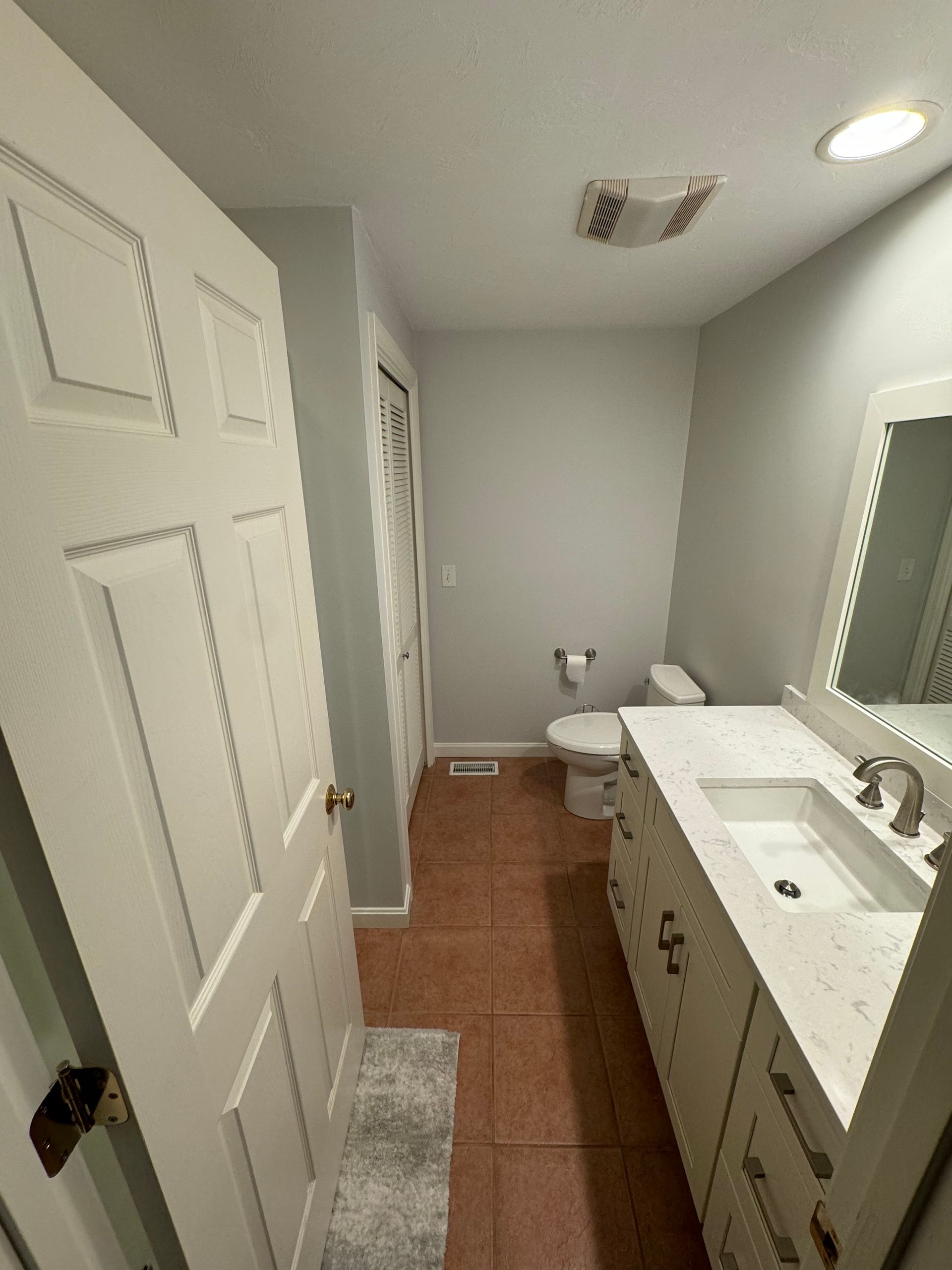 A bathroom with two sinks , a toilet , and a mirror.