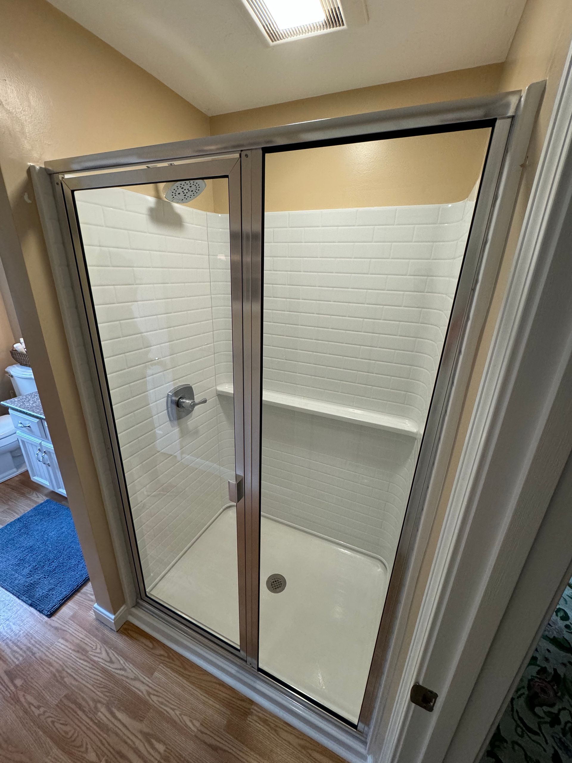 A bathroom with a walk in shower and a toilet.