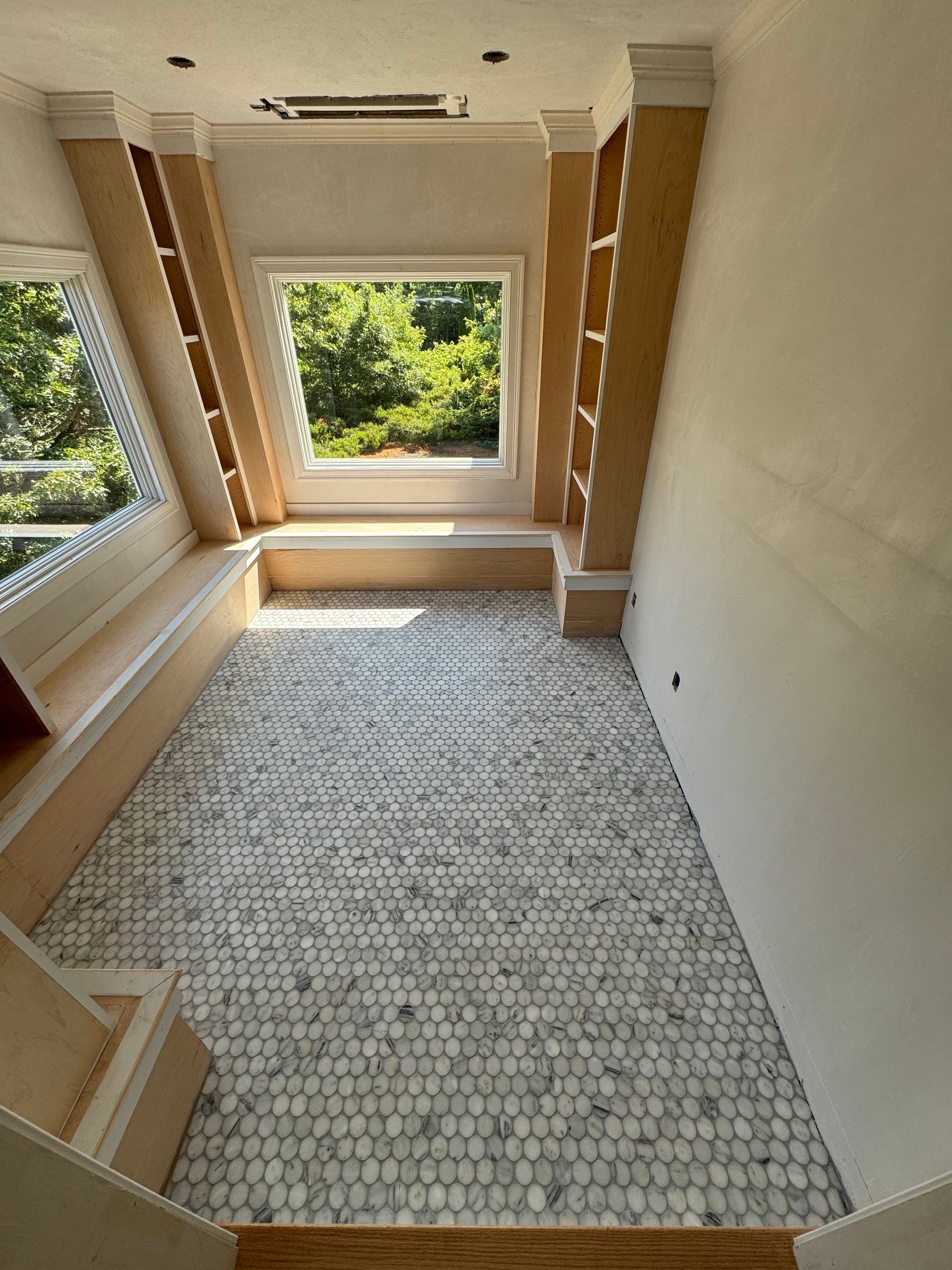 A room with a window and a tiled floor.