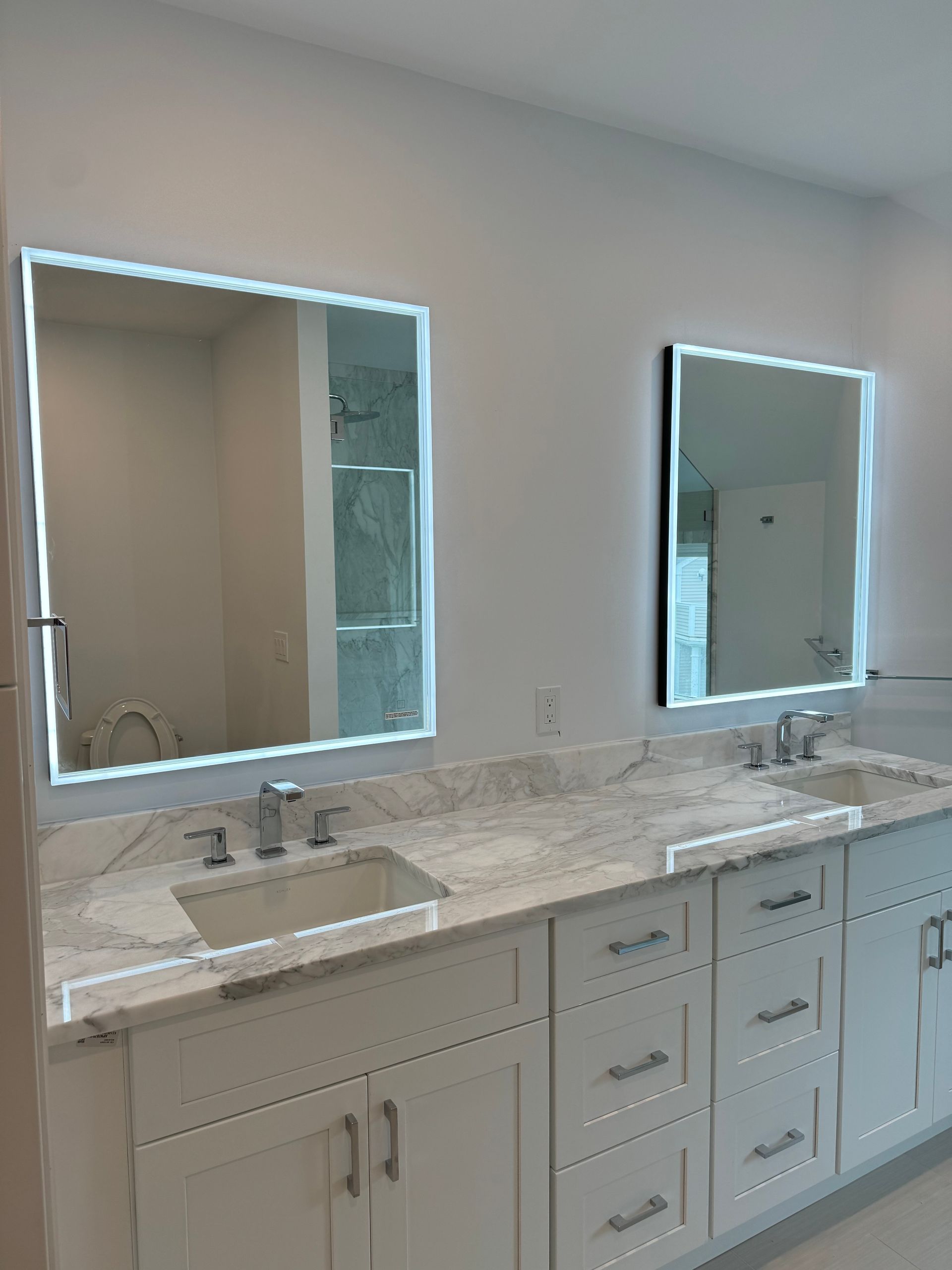 A bathroom with two sinks and two mirrors.