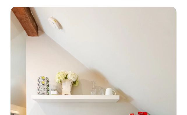 A white shelf with a vase of flowers on it