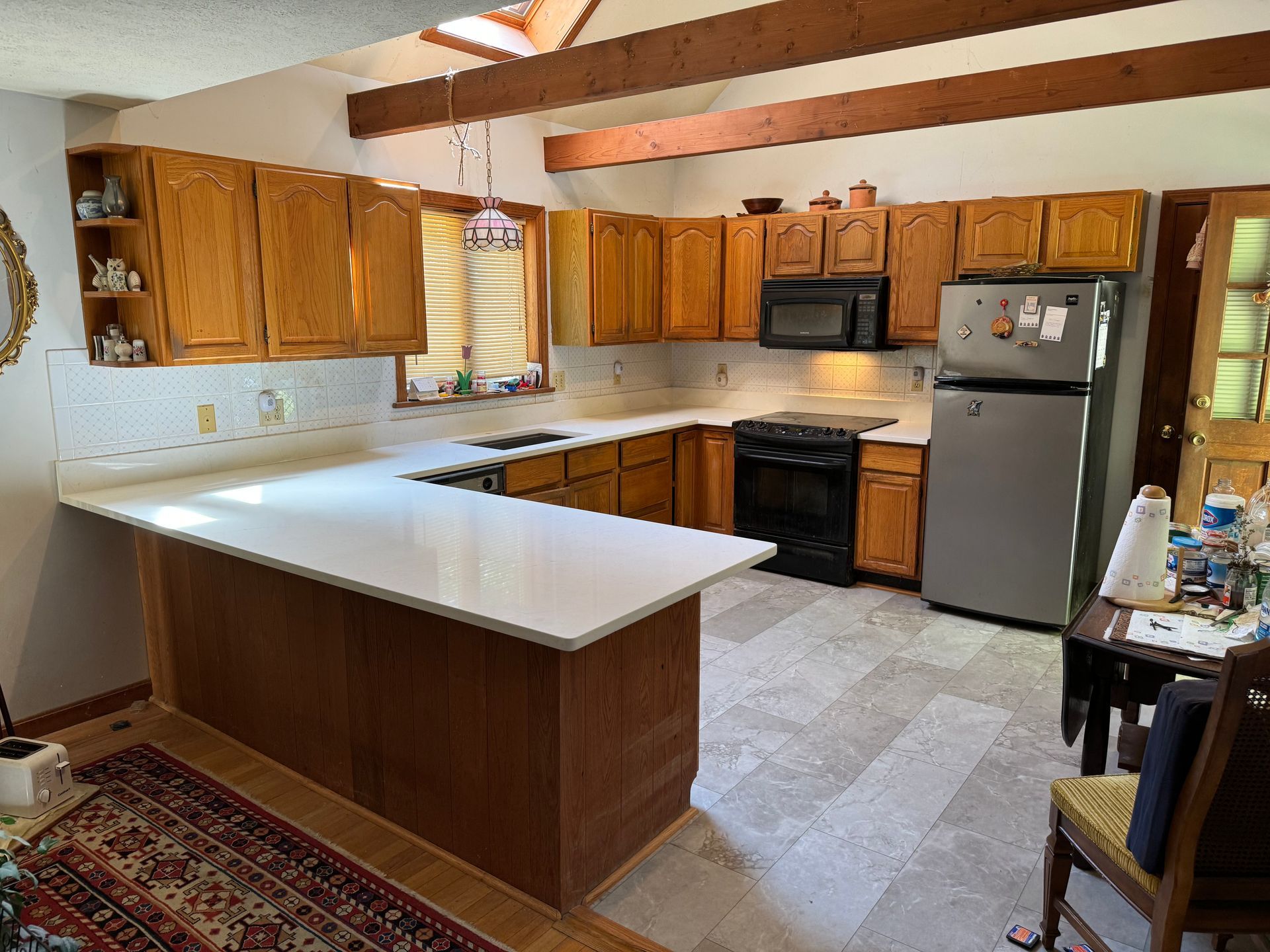 A kitchen with wooden cabinets and a stainless steel refrigerator