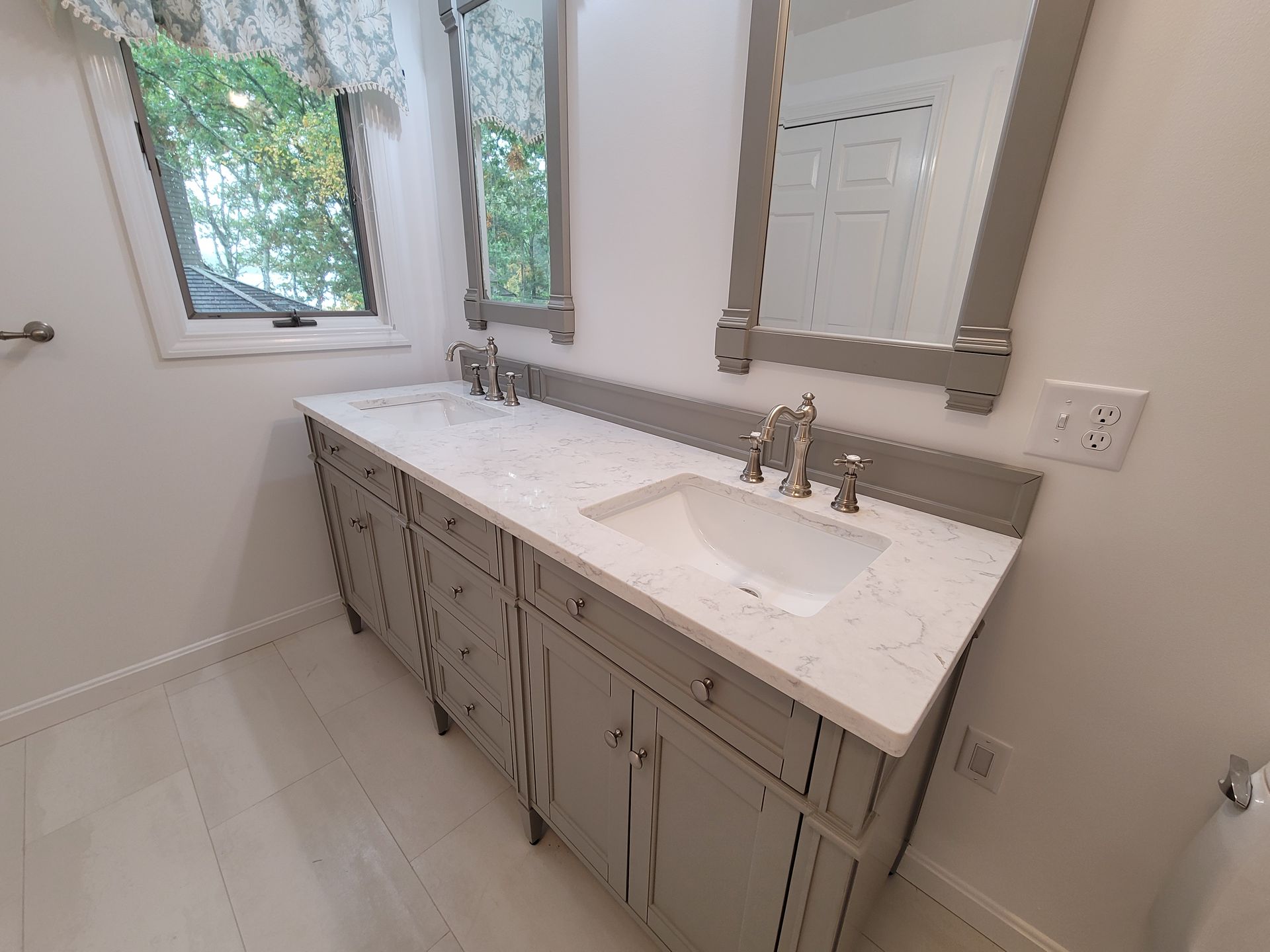 A bathroom with two sinks and two mirrors.