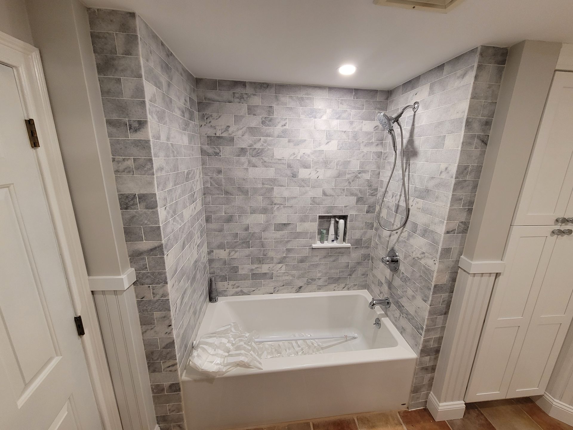 A bathroom with a bathtub and a shower.