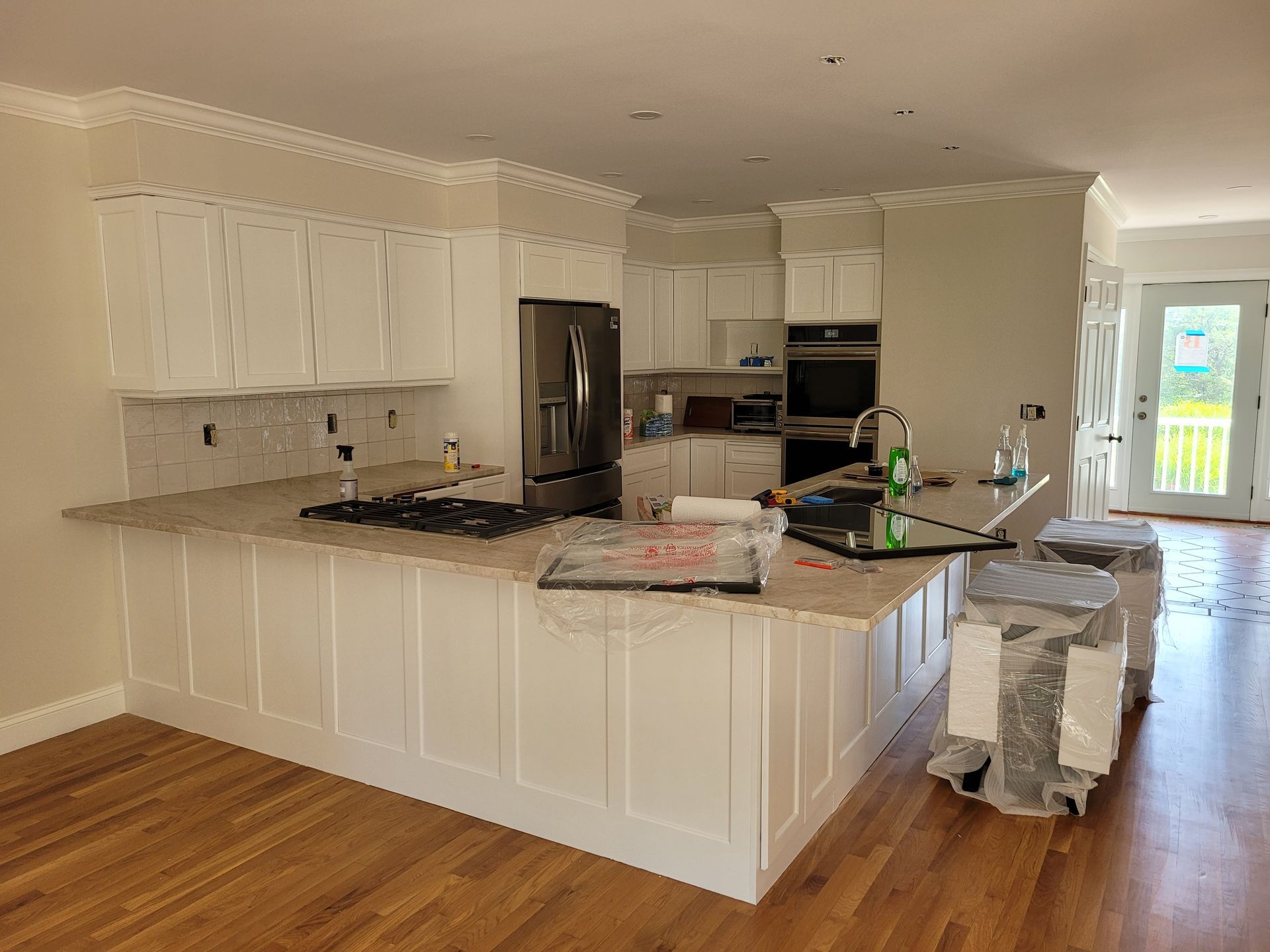 A kitchen with white cabinets and granite counter tops is being remodeled.