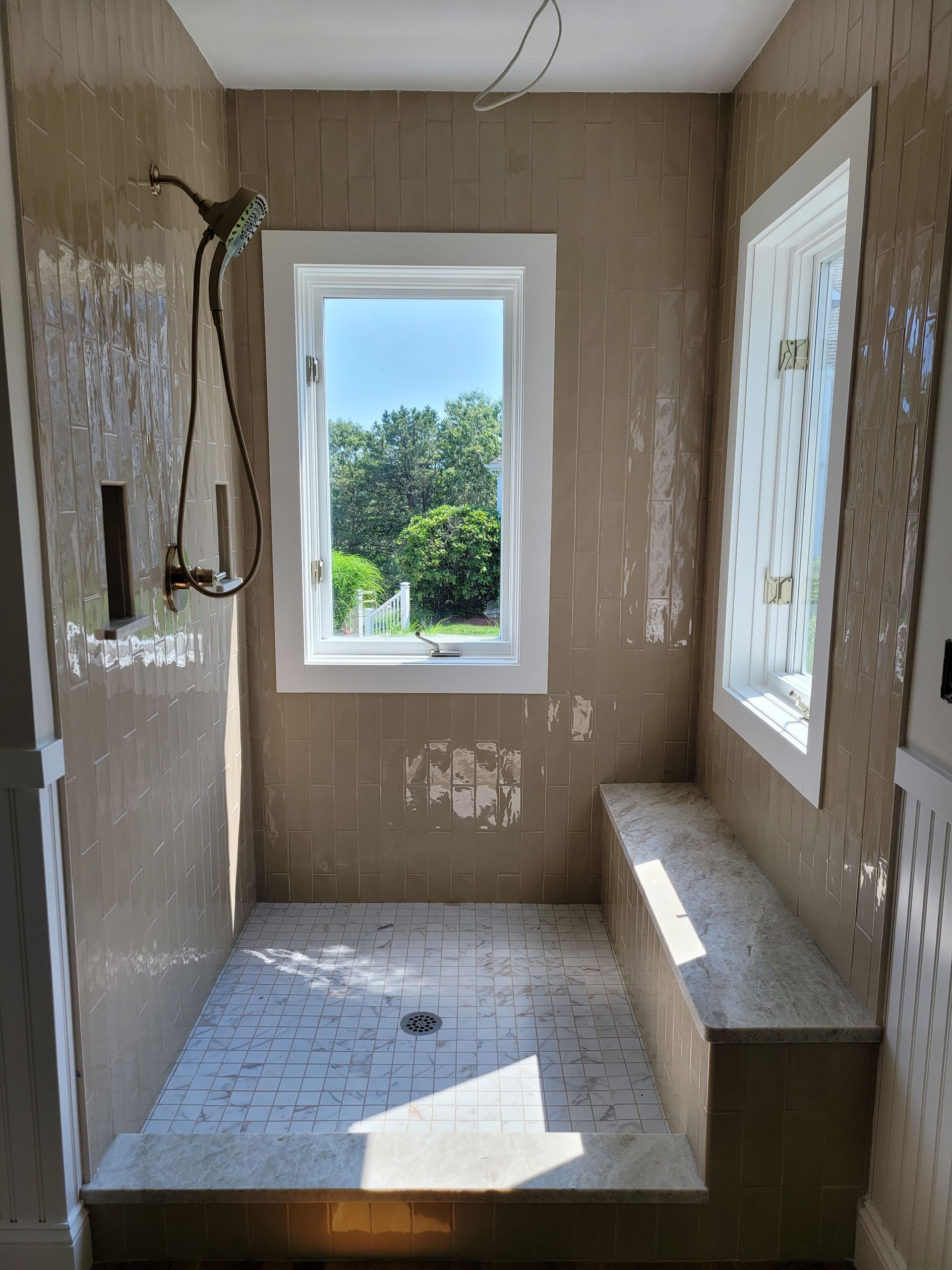 A bathroom with a shower and a window.