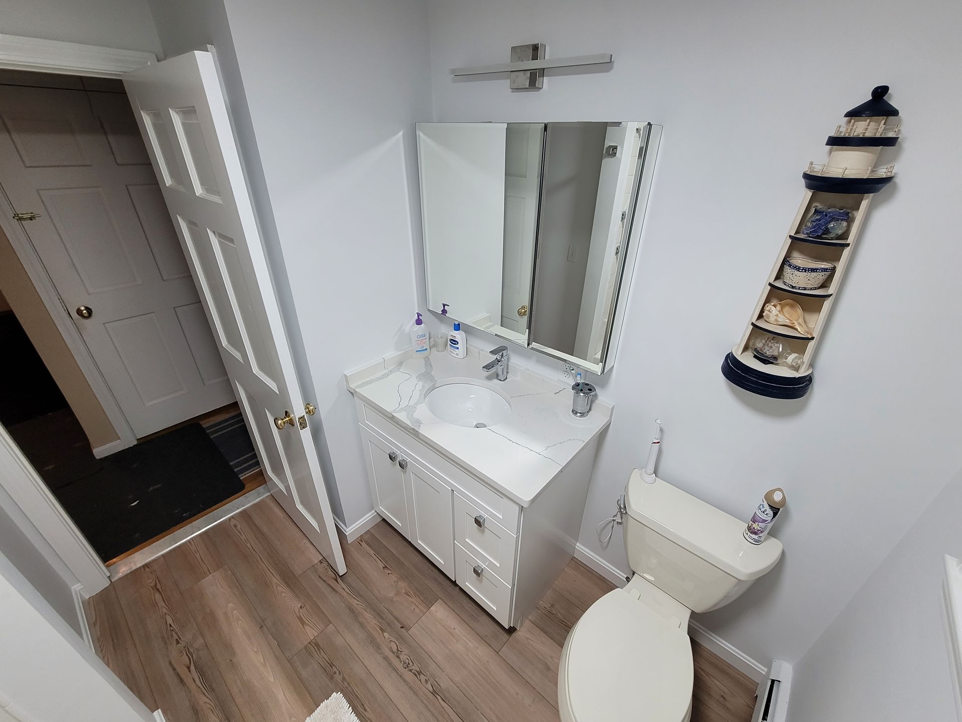 A bathroom with a sink , toilet and mirror.