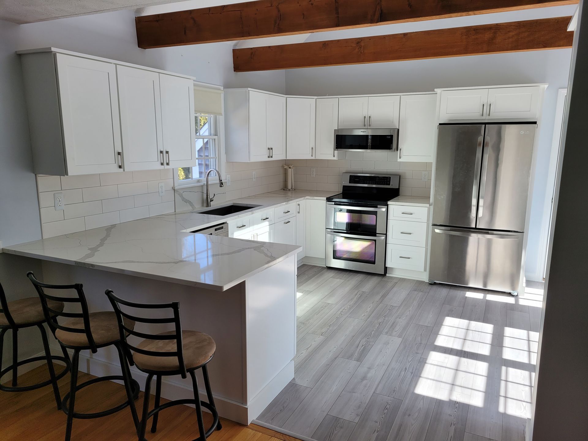A kitchen with white cabinets and stainless steel appliances