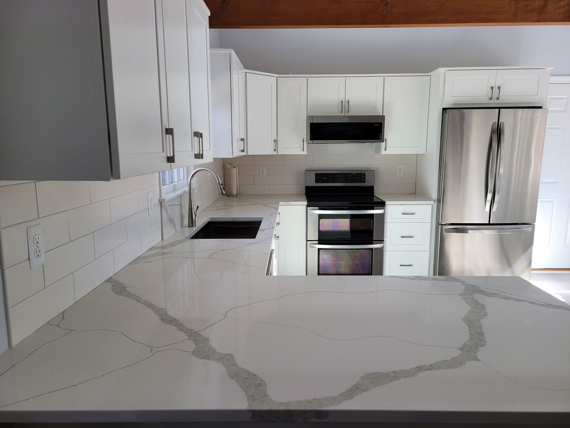 A kitchen with white cabinets and stainless steel appliances