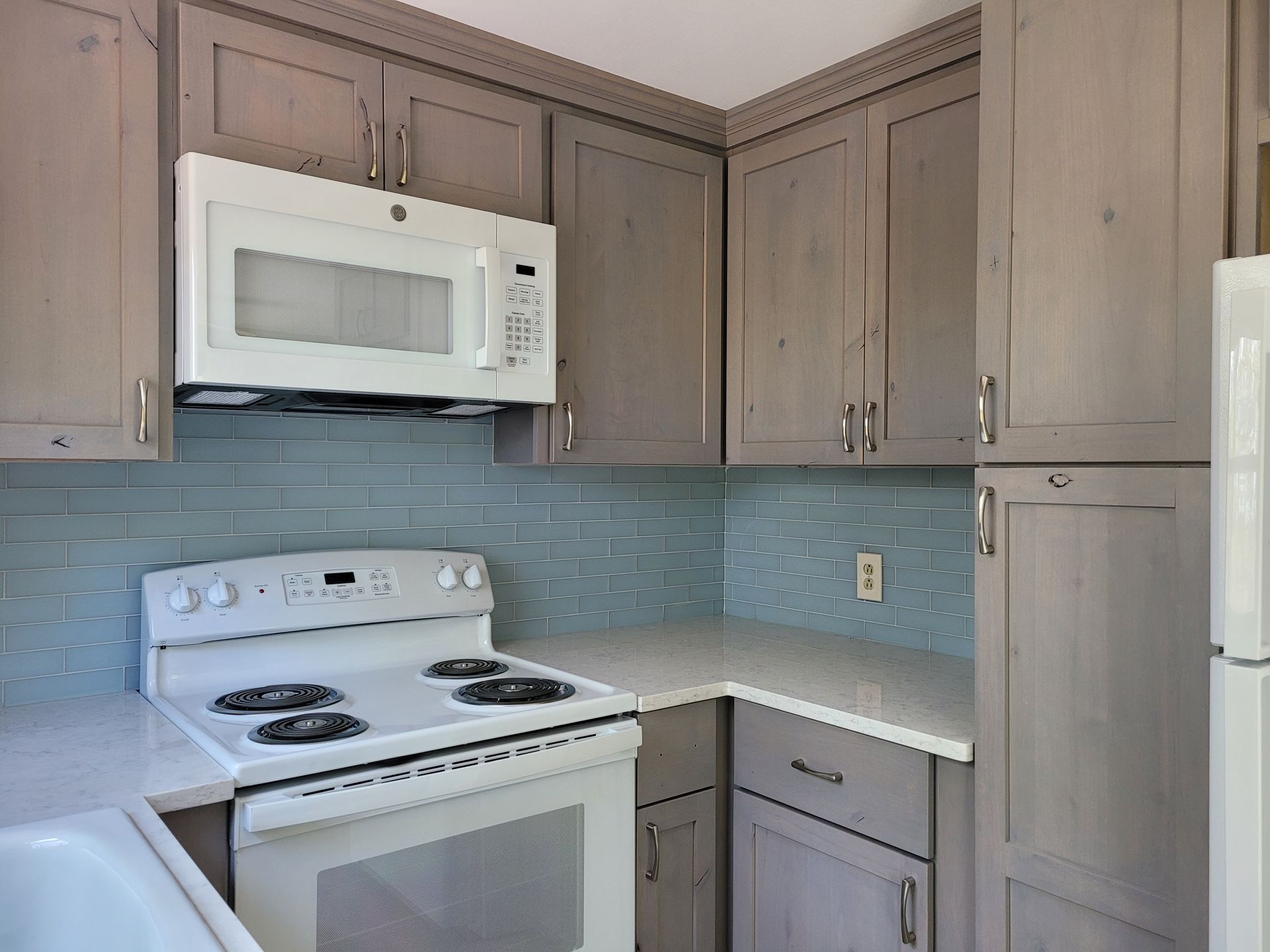 A kitchen with a stove , microwave and refrigerator
