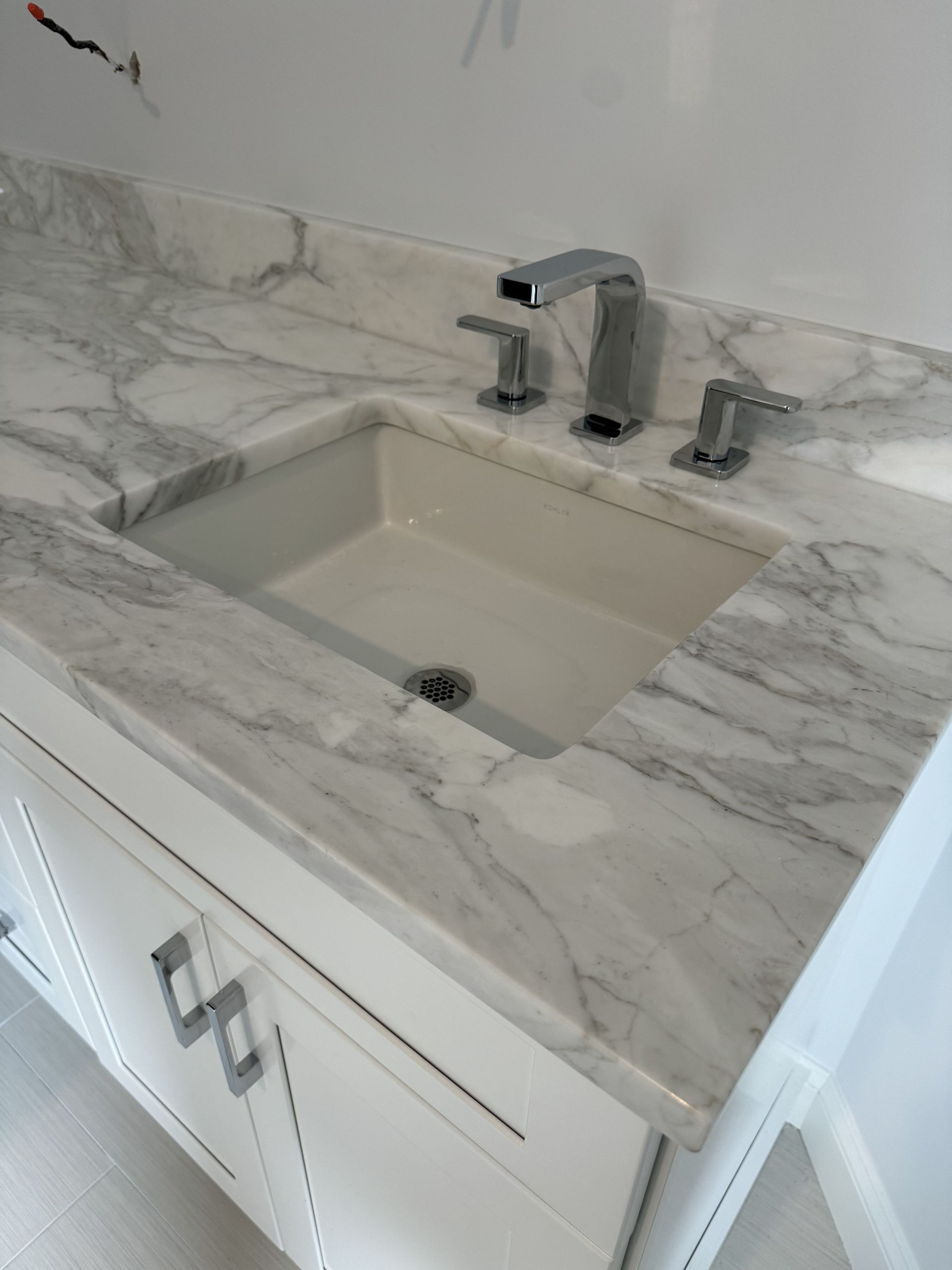 A bathroom sink with a marble counter top