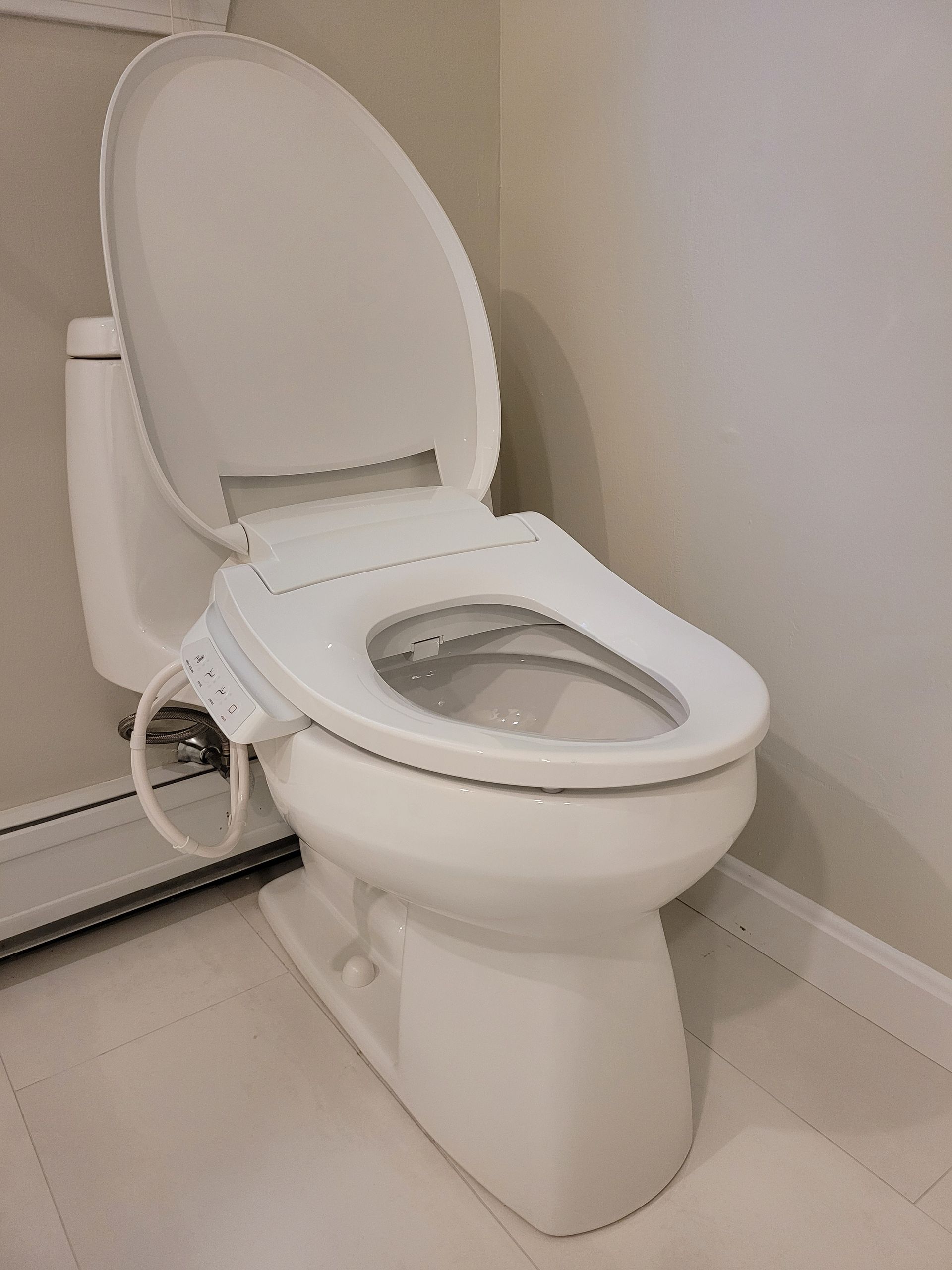 A white toilet with a bidet attached to it in a bathroom.