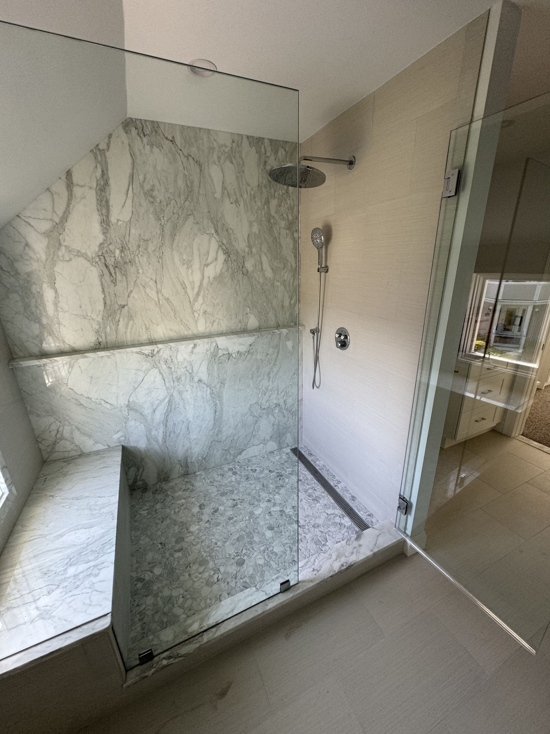 A bathroom with a walk in shower and a shower head.