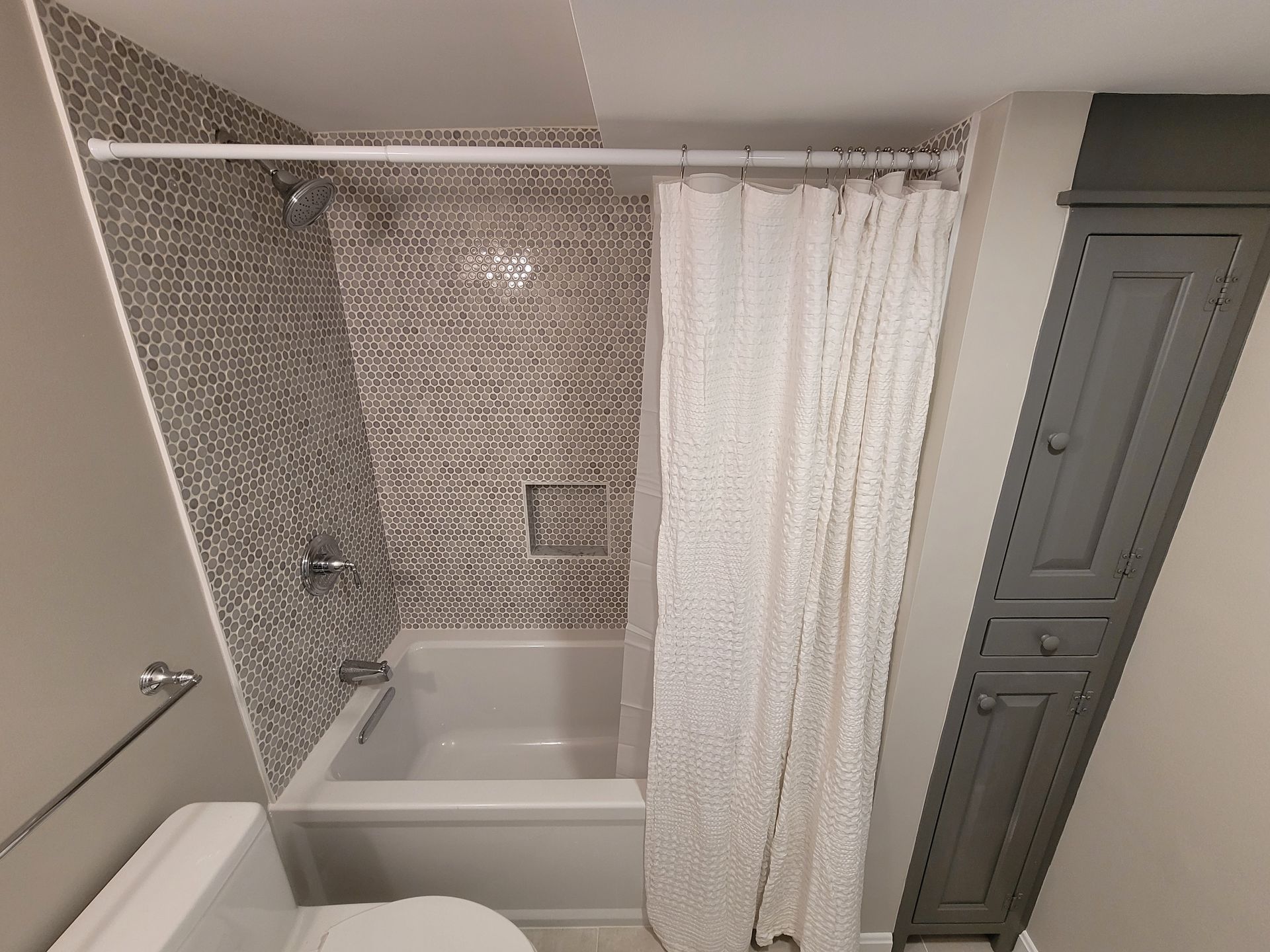 A bathroom with a tub , toilet and shower curtain