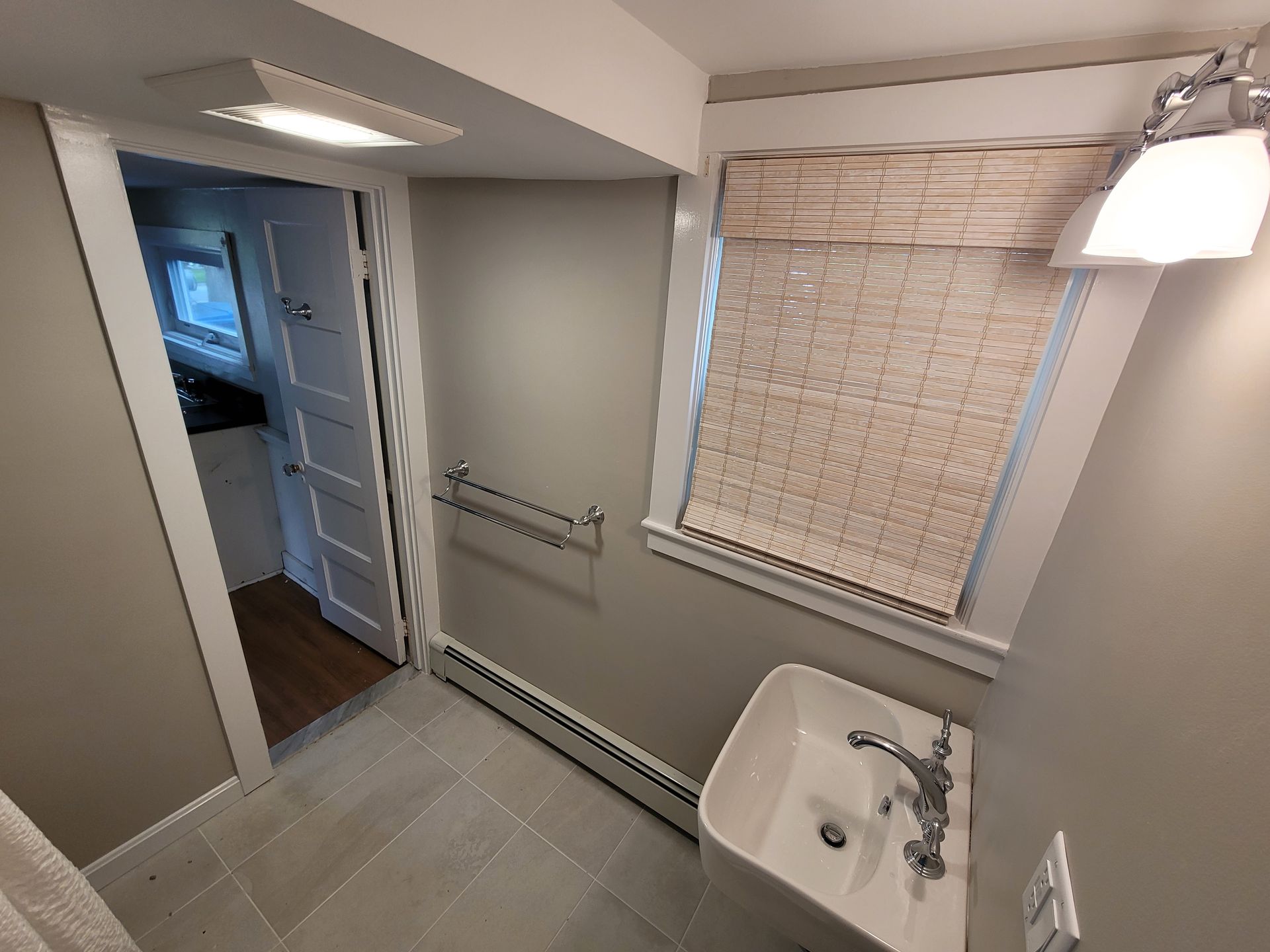 A bathroom with a sink and a window with blinds
