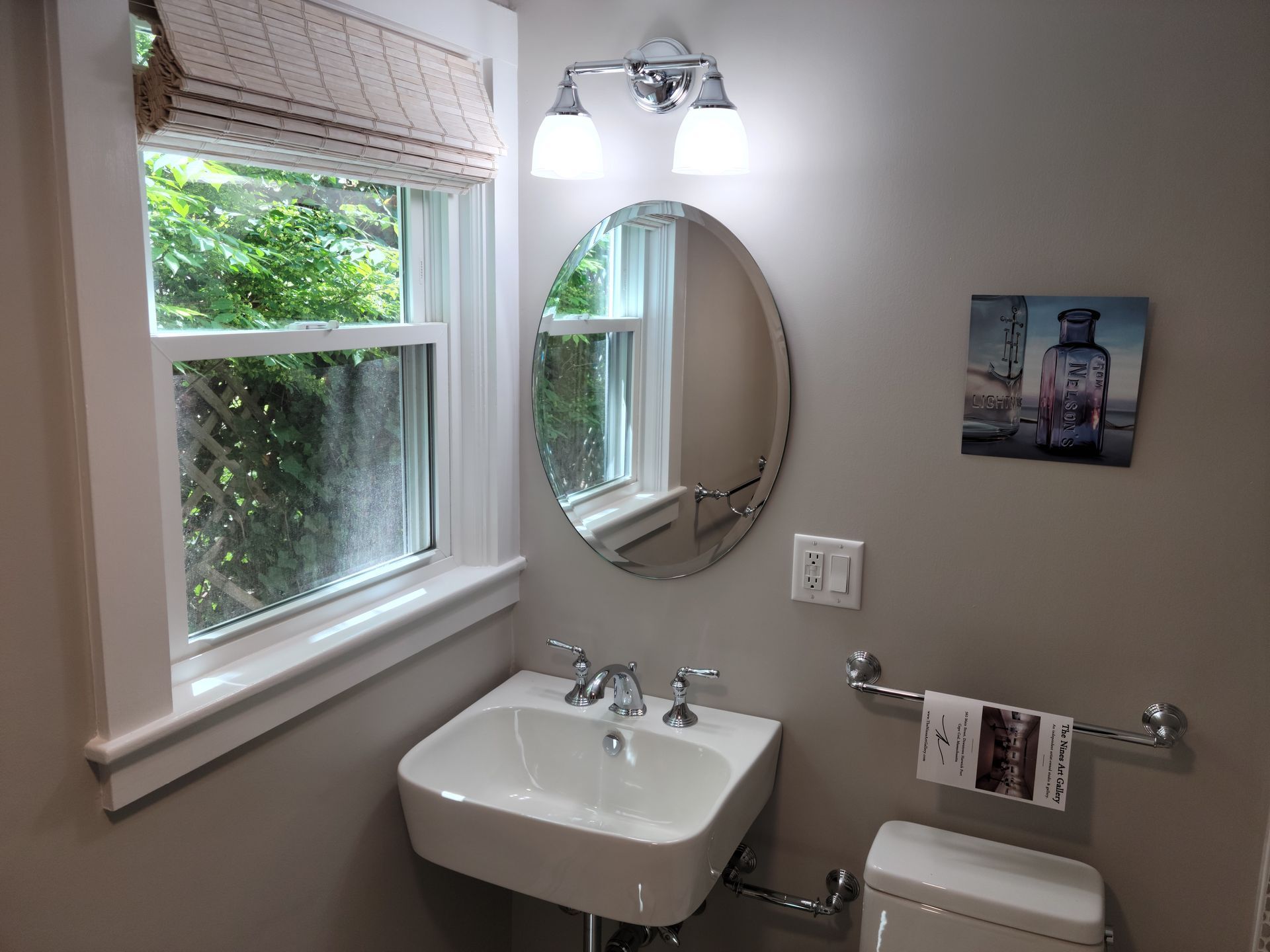 A bathroom with a sink a toilet and a window