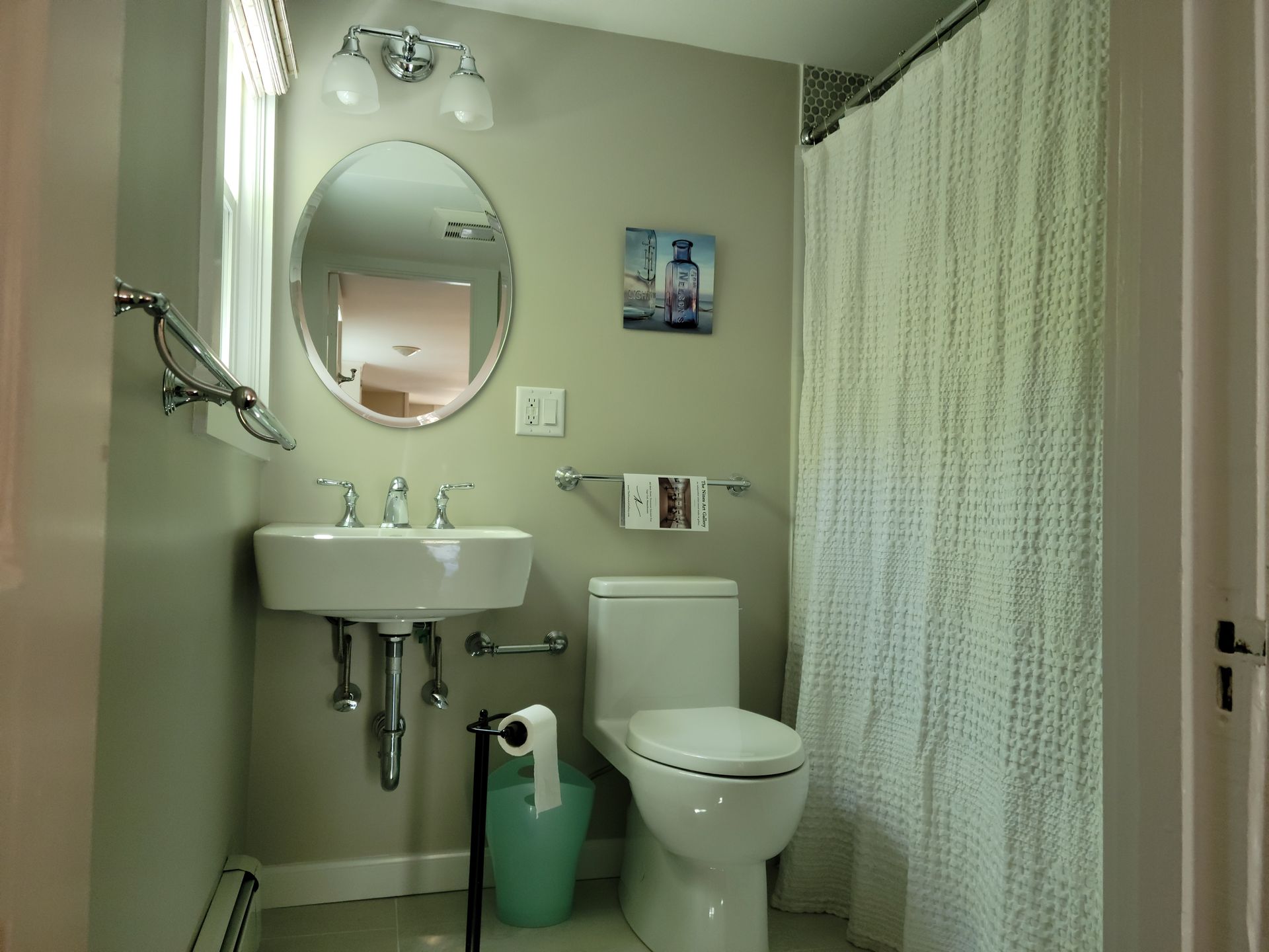 A bathroom with a toilet a sink and a shower curtain