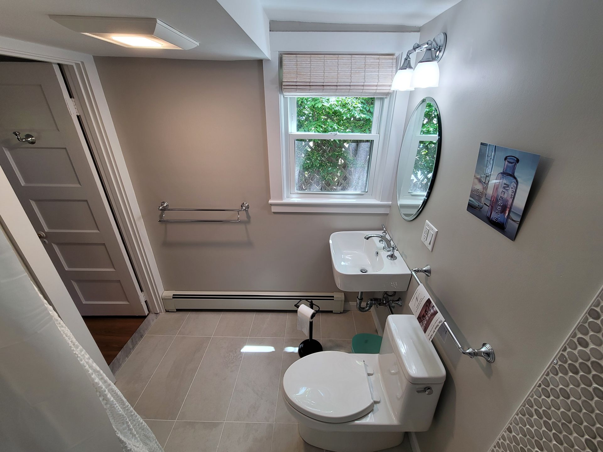A bathroom with a toilet , sink and mirror