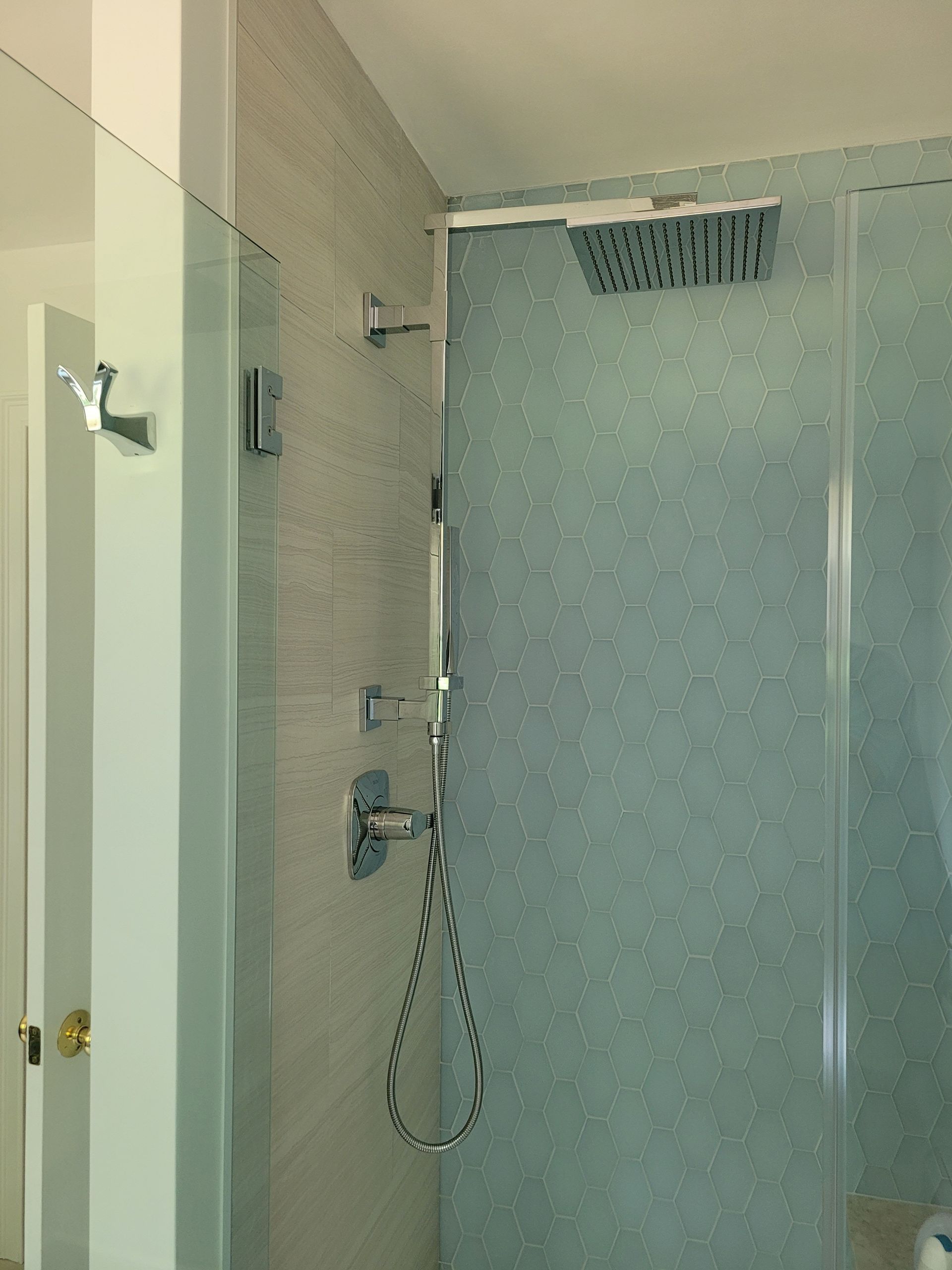 A bathroom with a shower and a mirror