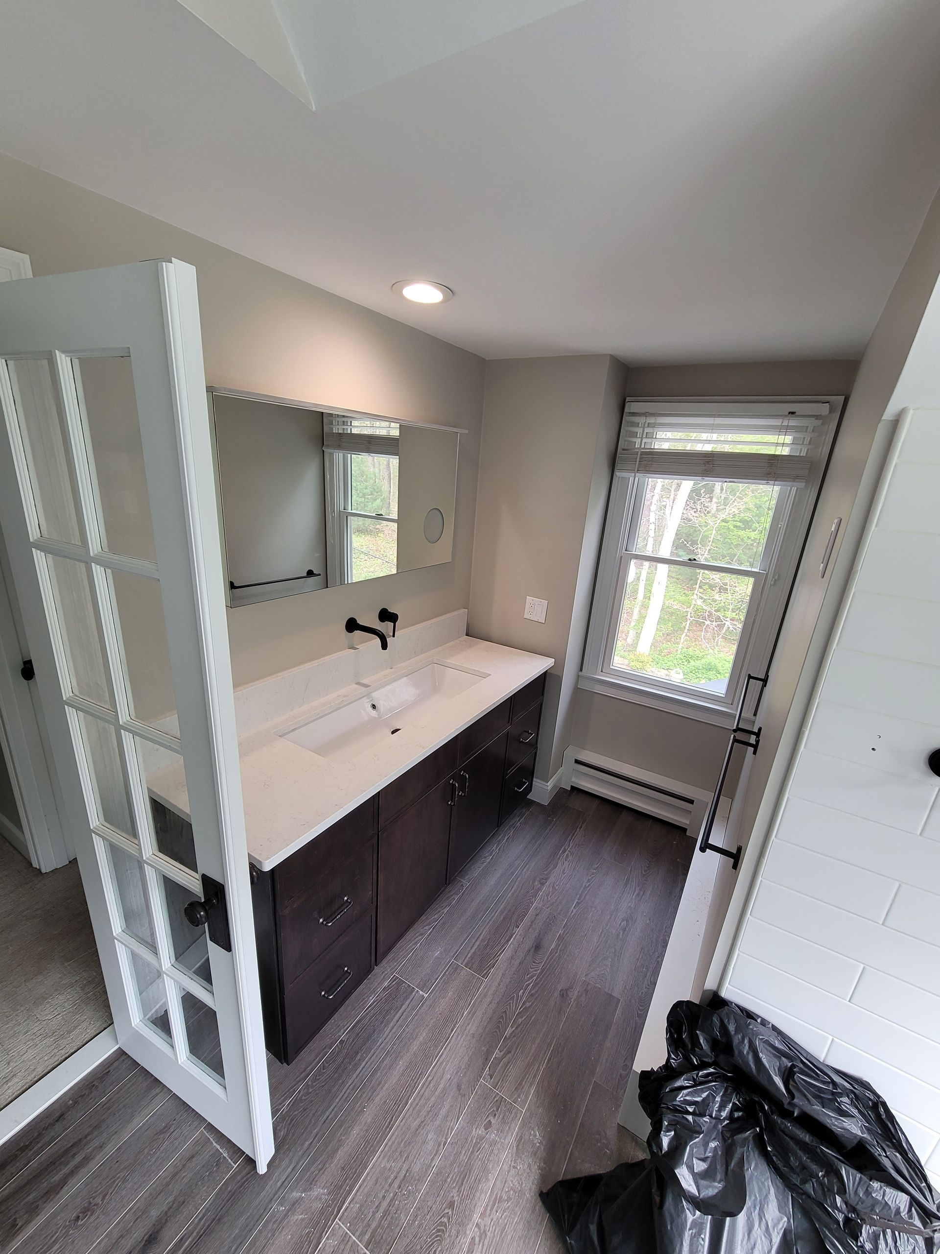 A bathroom with two sinks , a mirror and a window.