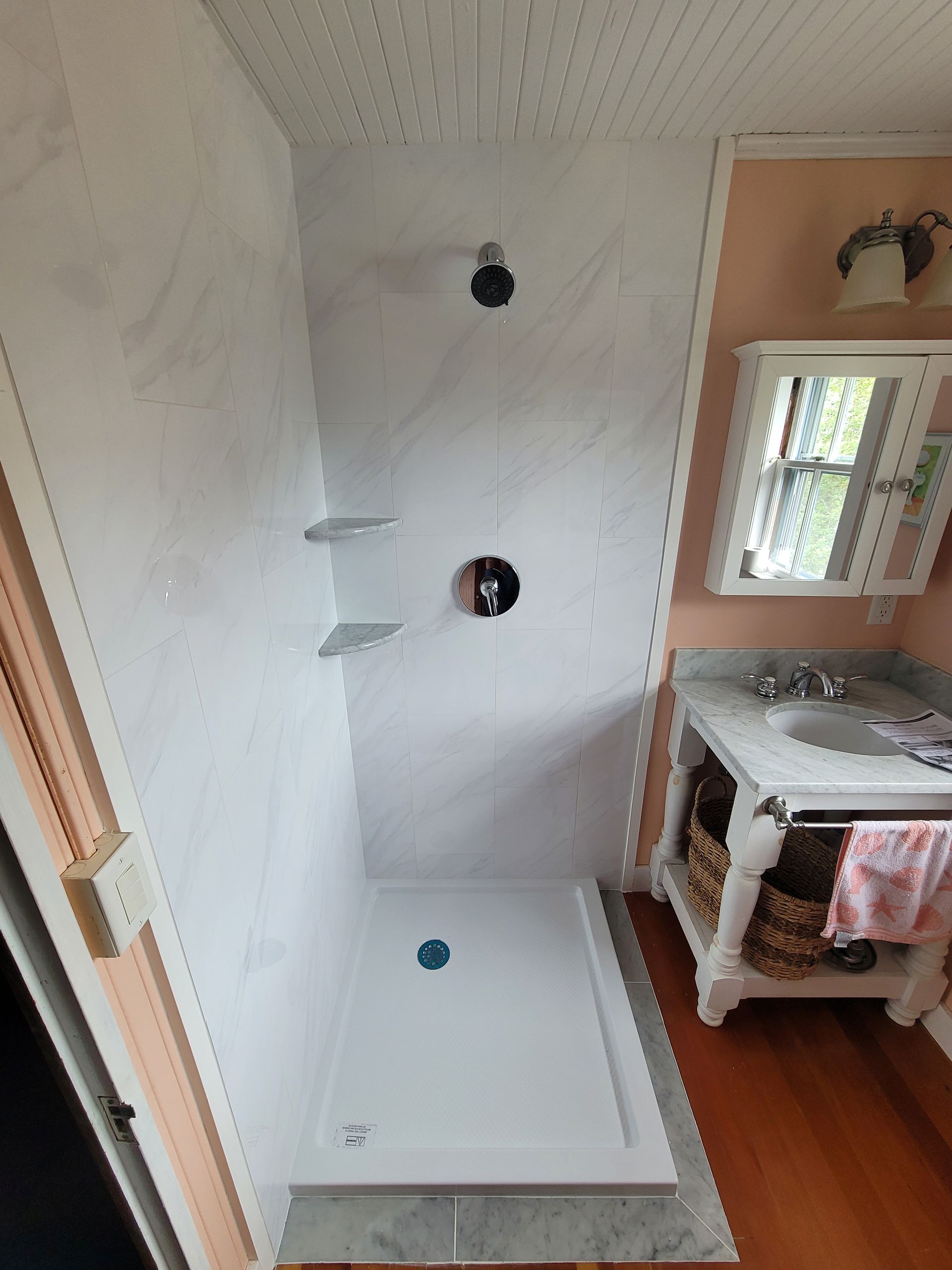 A bathroom with a walk in shower and a sink.