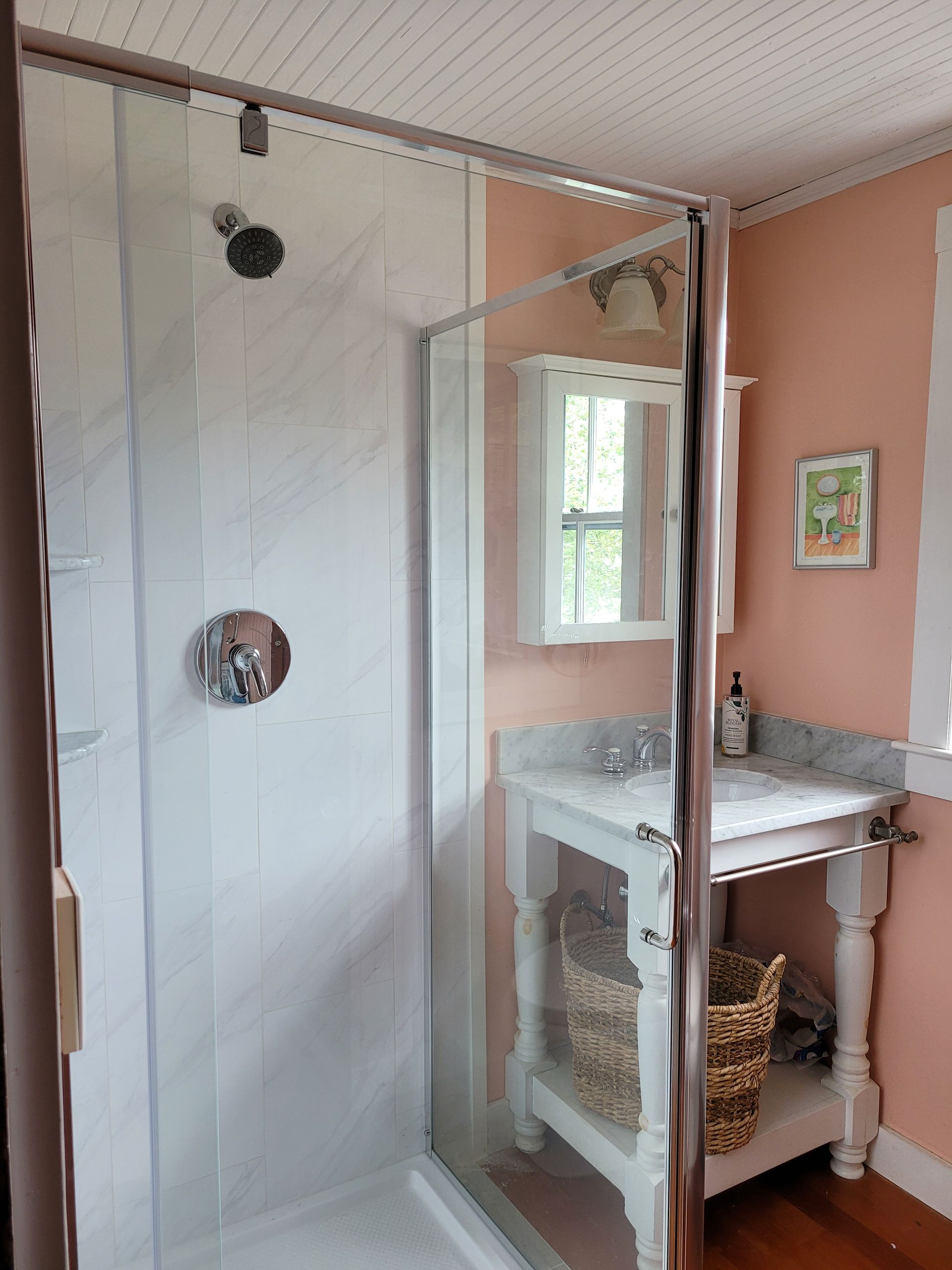 A bathroom with a walk in shower and a sink