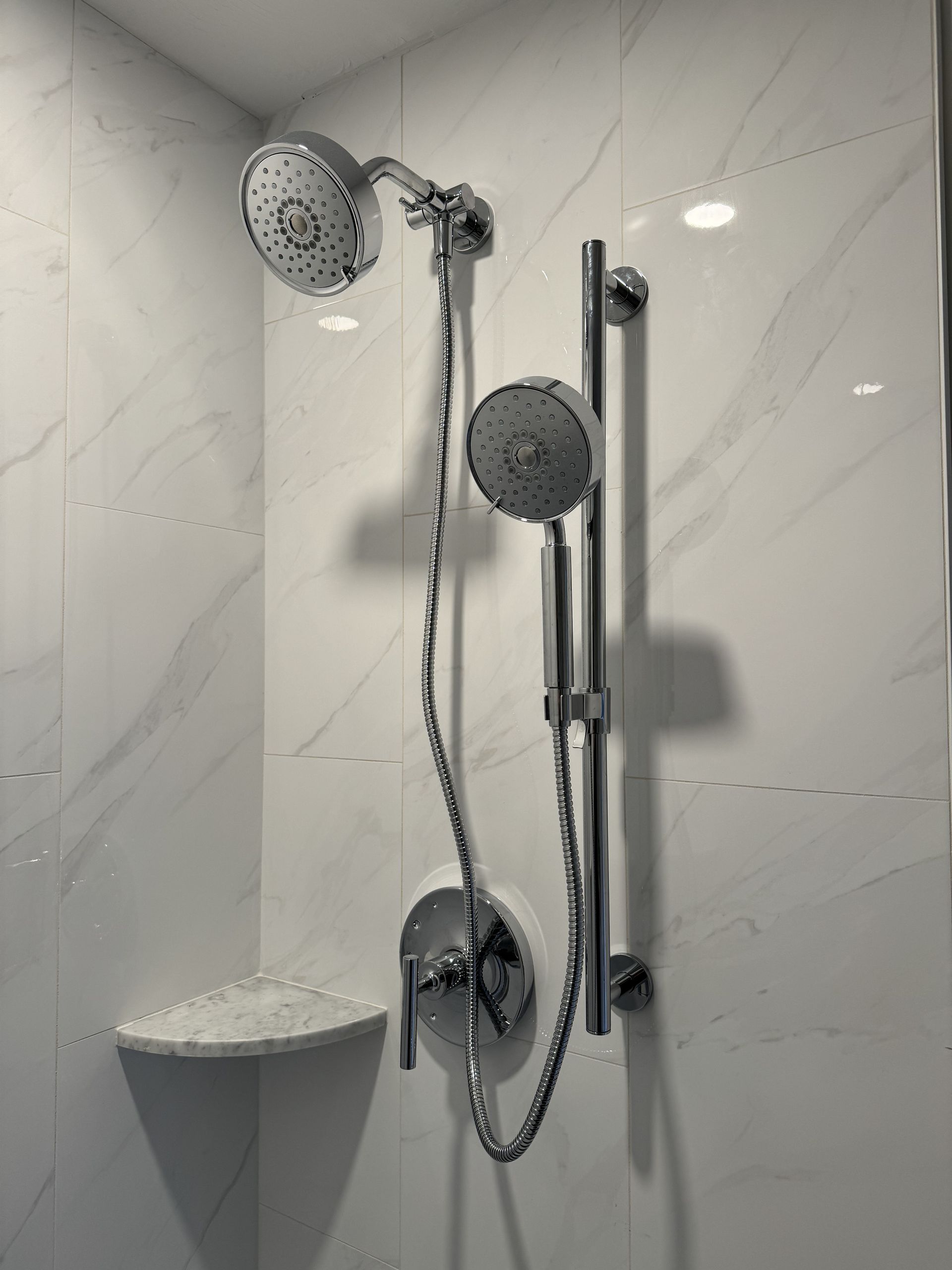 A shower head is hanging from the wall in a bathroom.